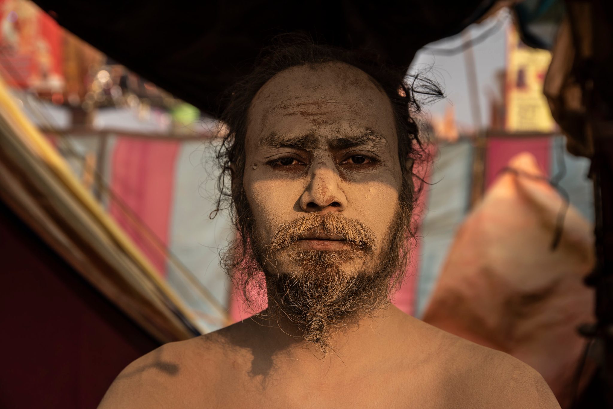 Sadhu meditates in his tent while offering blessings to passerby’s