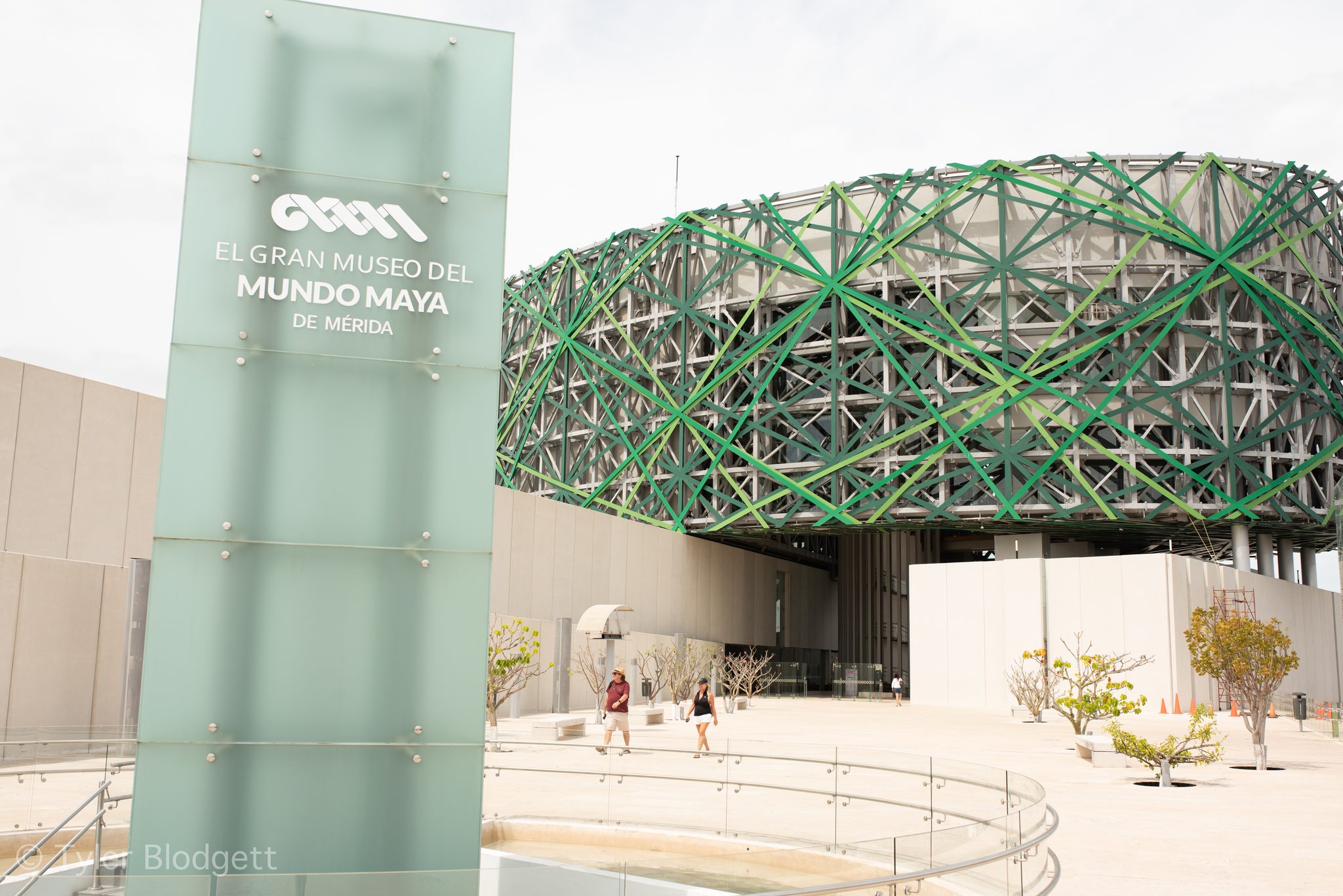 The museum's sign stands in the sun beneath its woven green canopy.