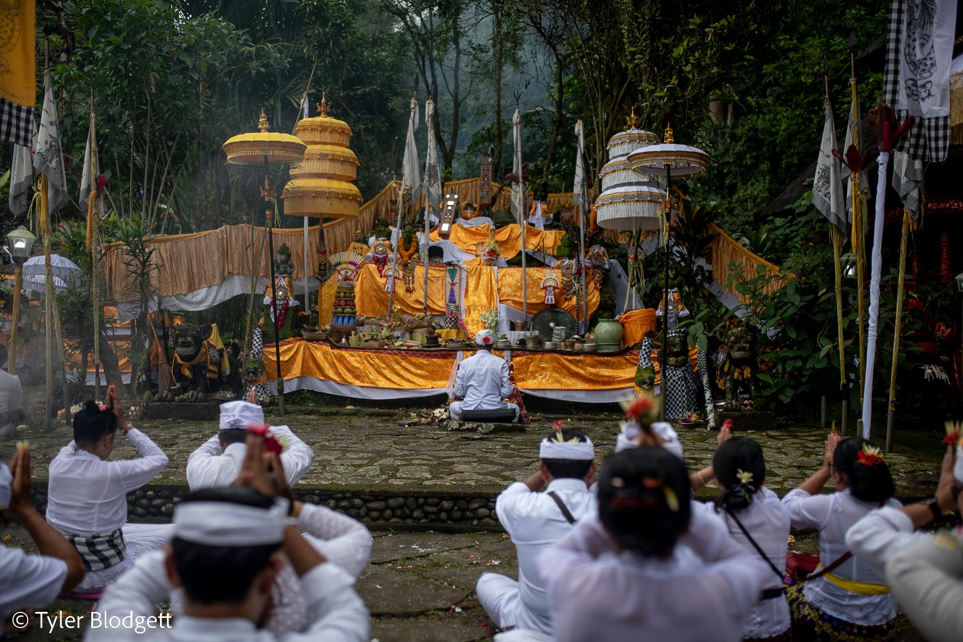 Hands rise to foreheads in prayer as incense drifts across the golden shrine.