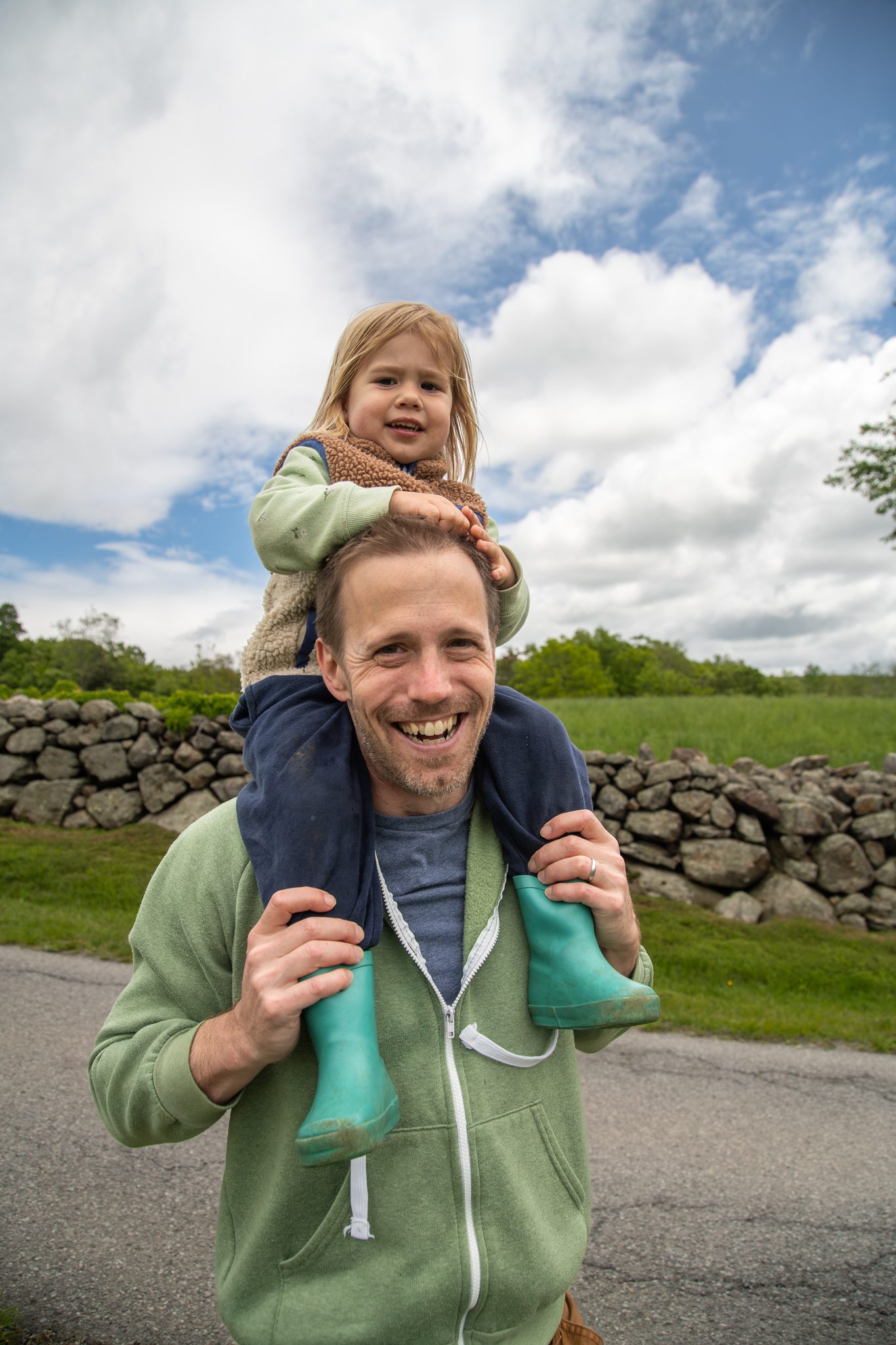 A little girl rides high on her father's shoulders.