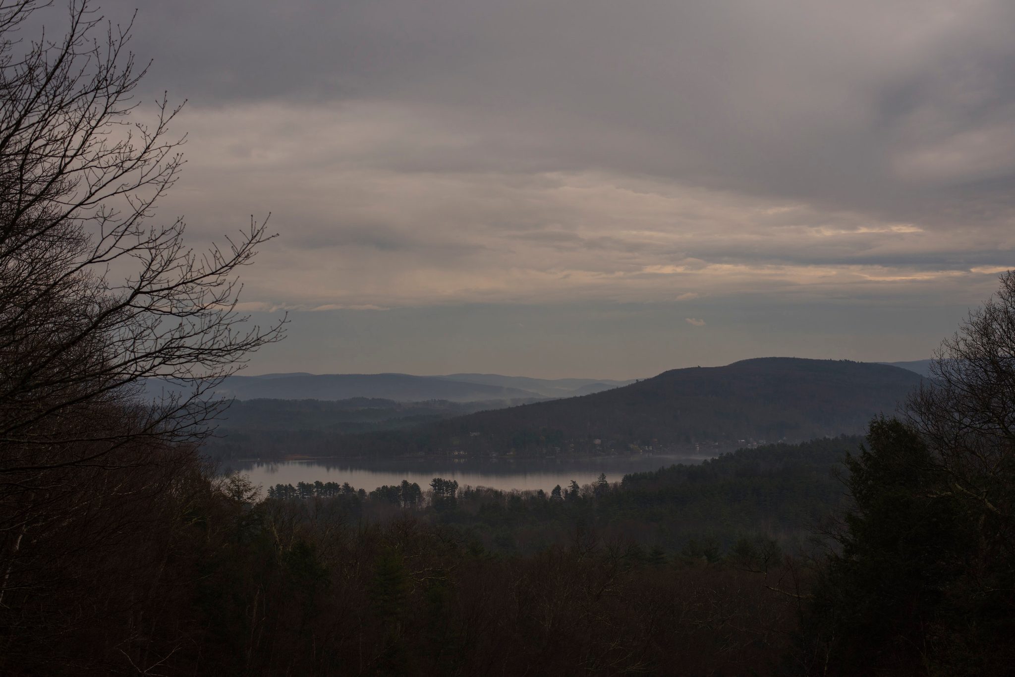 Dusk settles over the hills and a lake far below.