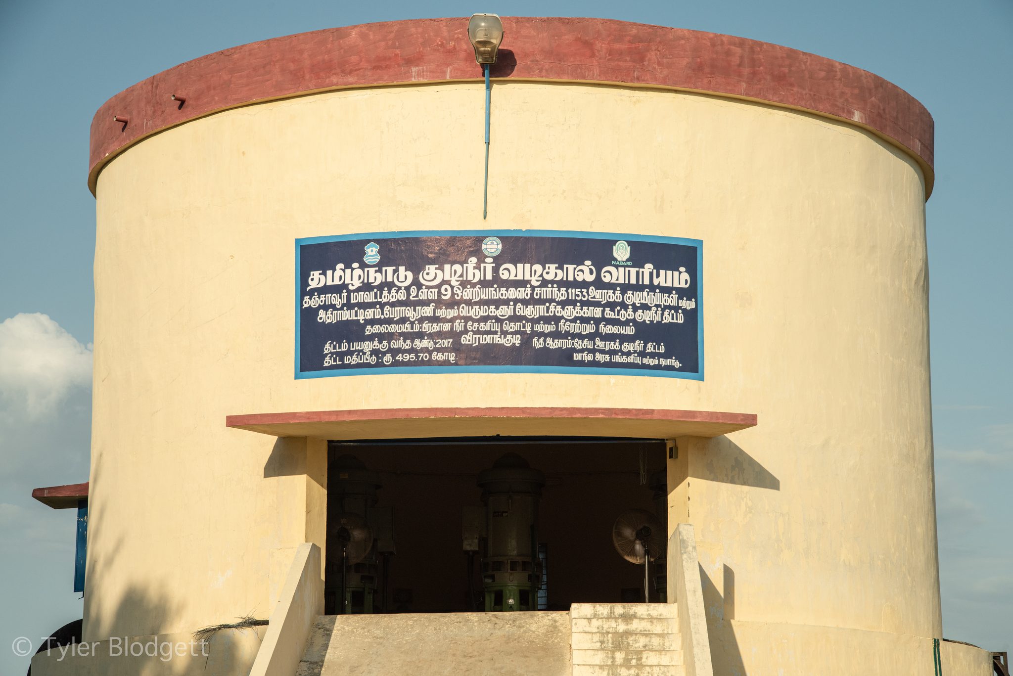The round pumping station stands under a clear blue sky.