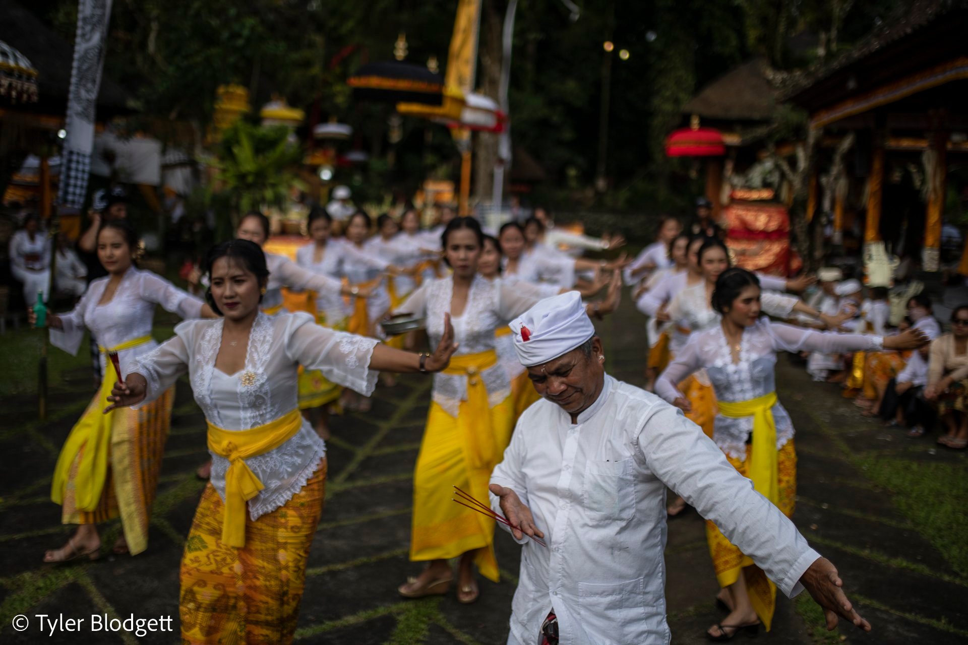 The dance moves as one body, hands turning in the evening light.