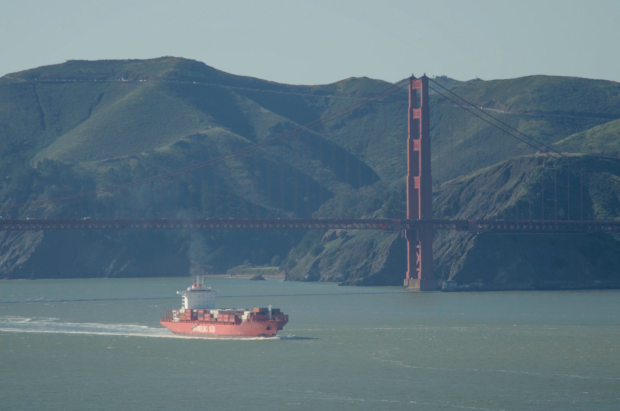 A container ship slides beneath the Golden Gate Bridge.