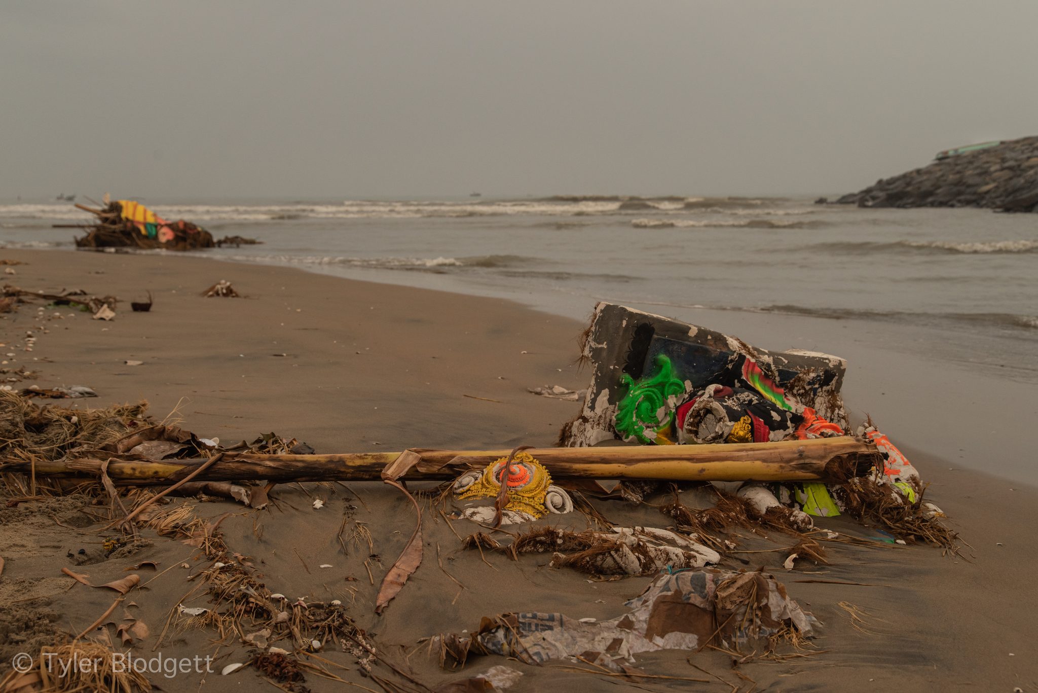 Colorful debris tangles on the beach where the river meets the sea.