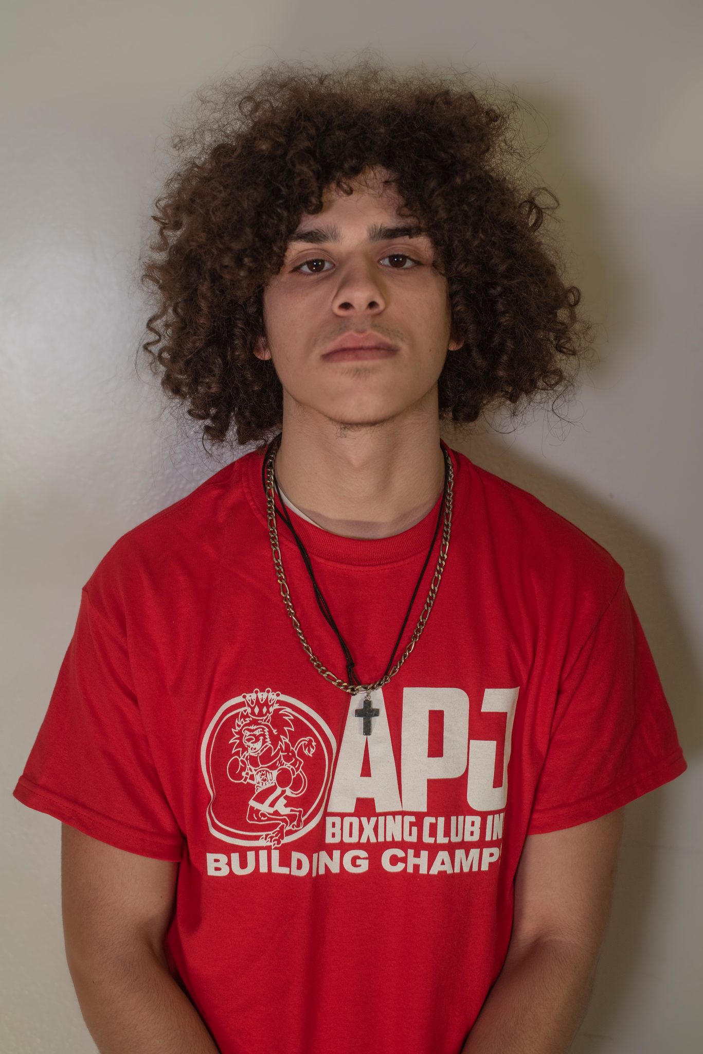 Curls, gold chain and a steady stare.