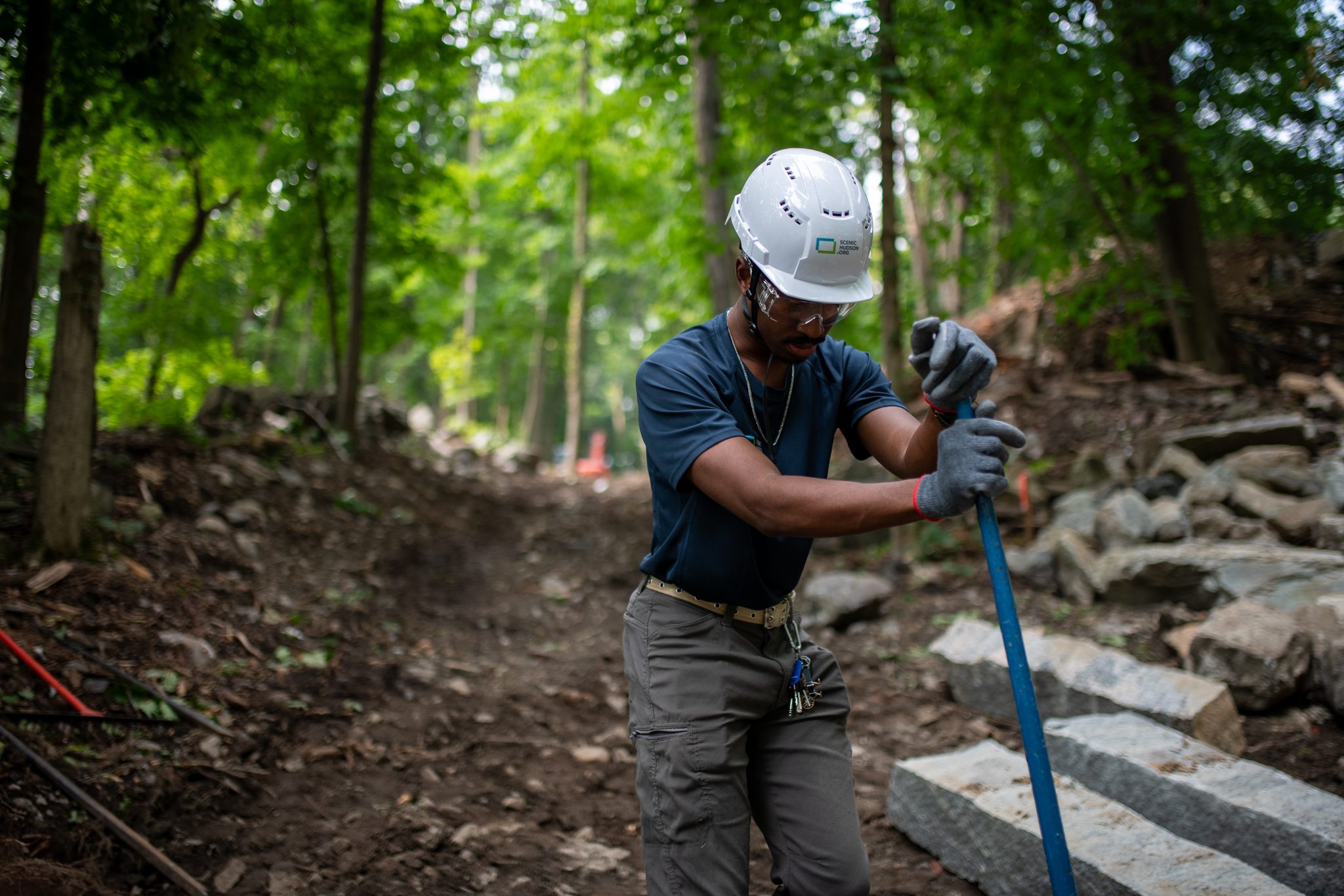 A crew member leans on his bar at the top of a line of new steps.