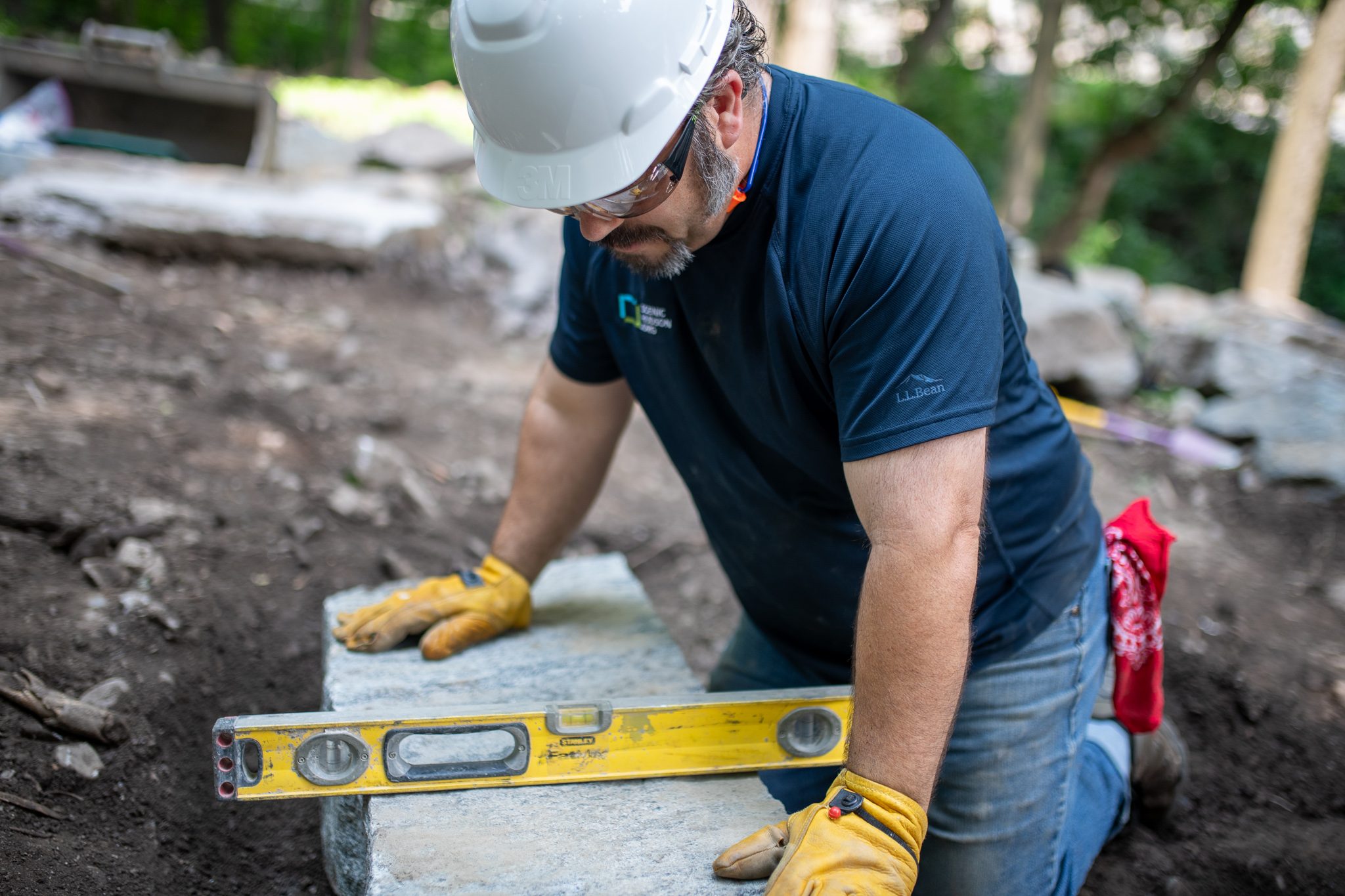 A level rests across the step as he presses it down.