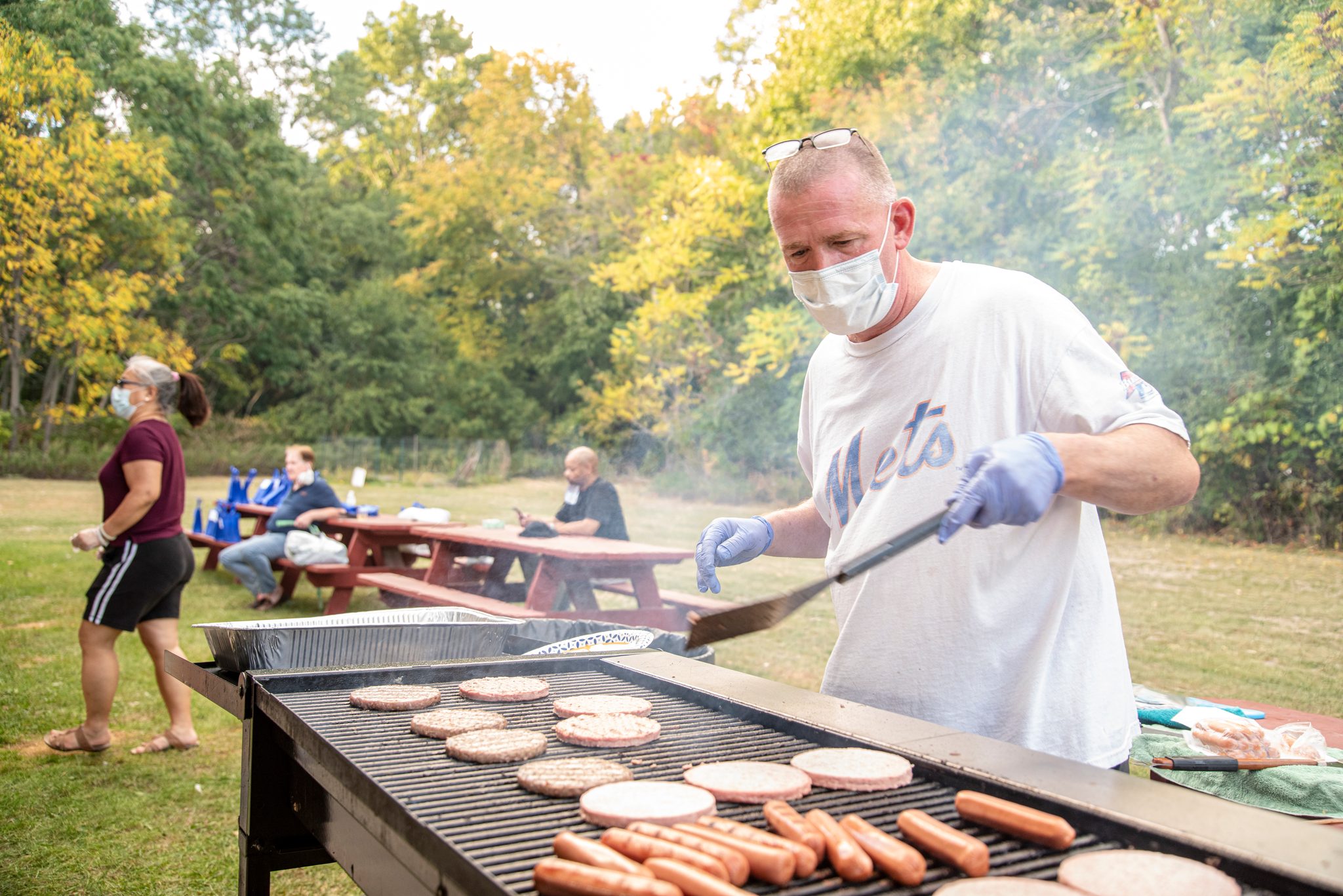 The grill master works a full rack of burgers.