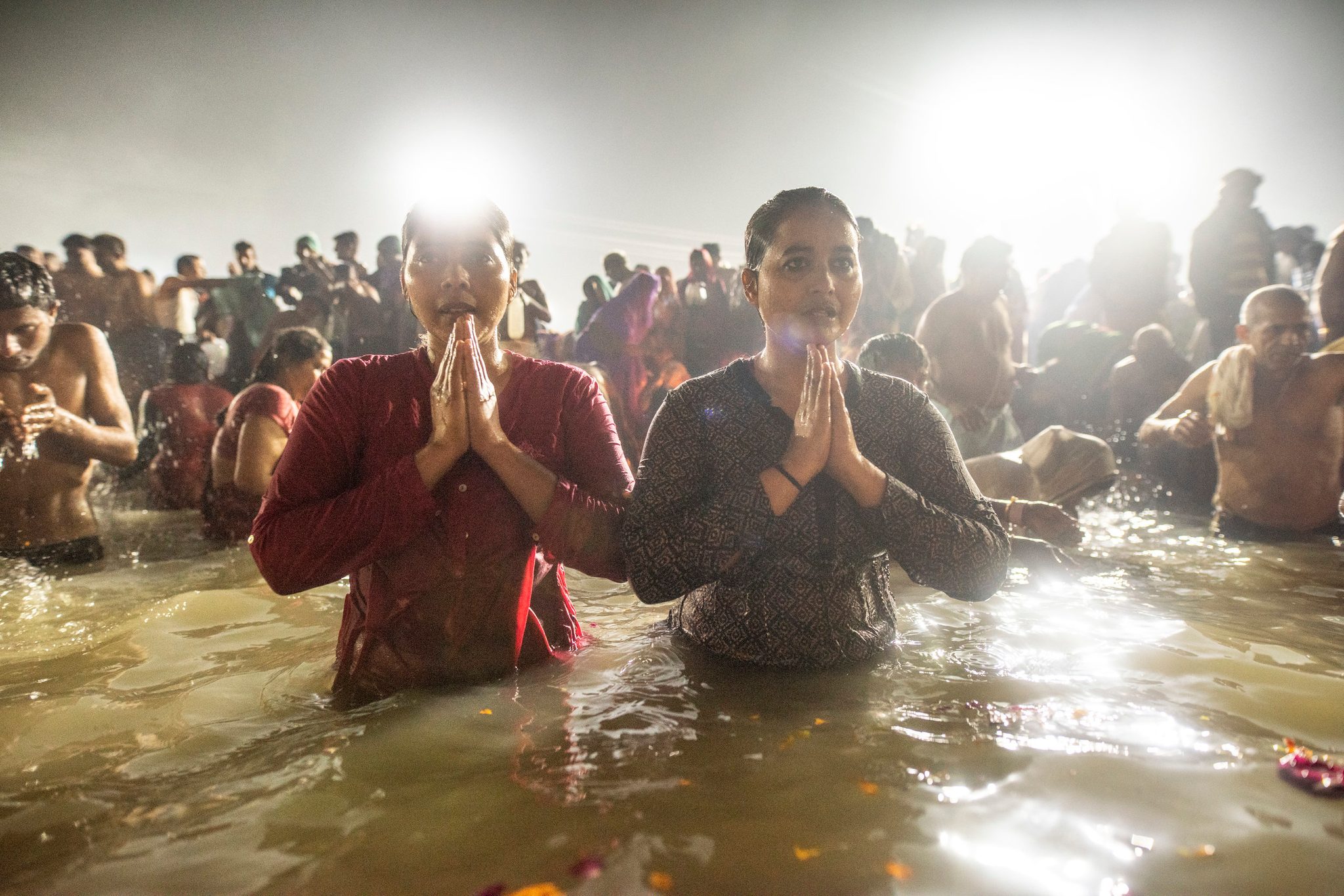 Two young women pray in the Ganges