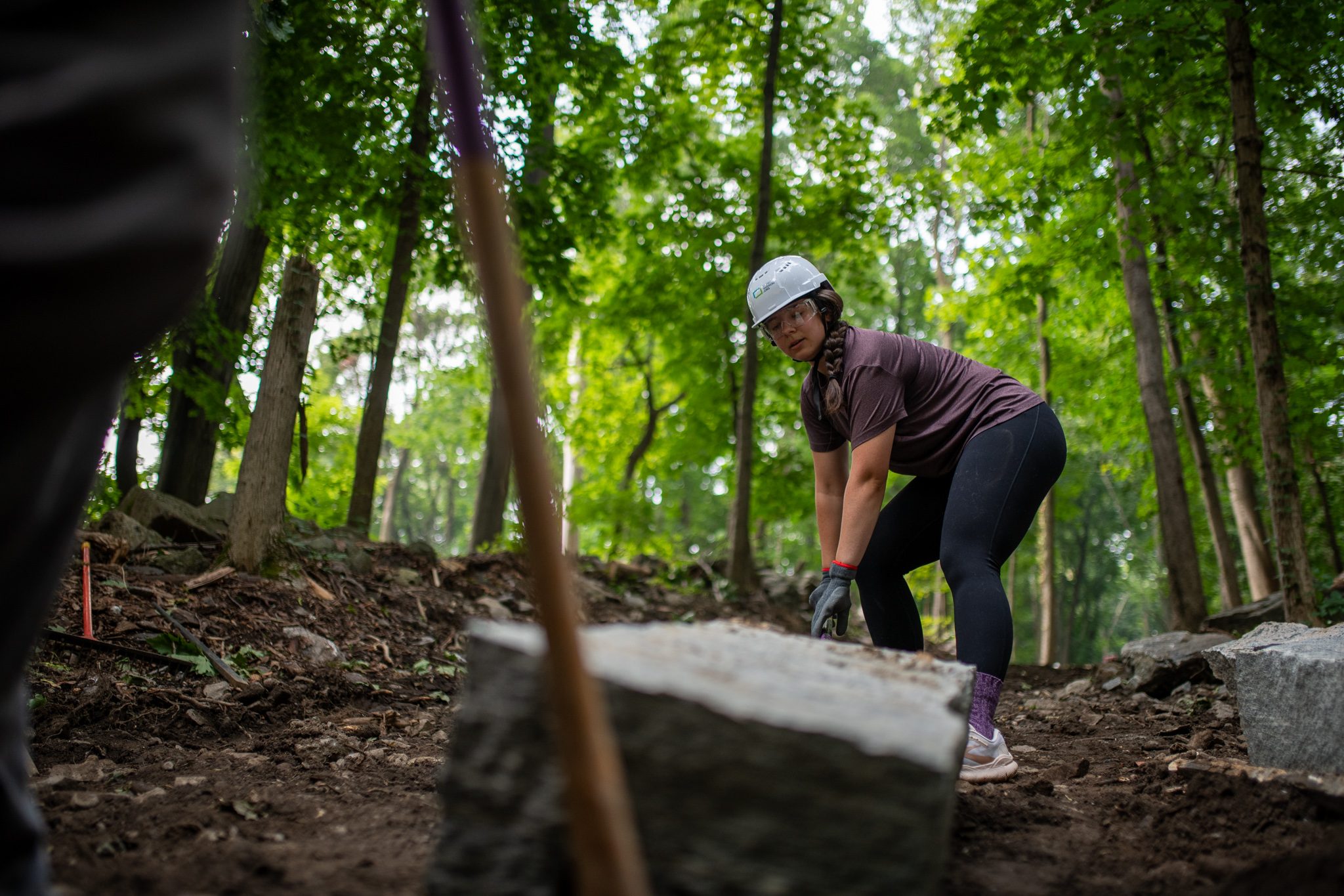 Framed by a pry bar, a crew member bends to the work.