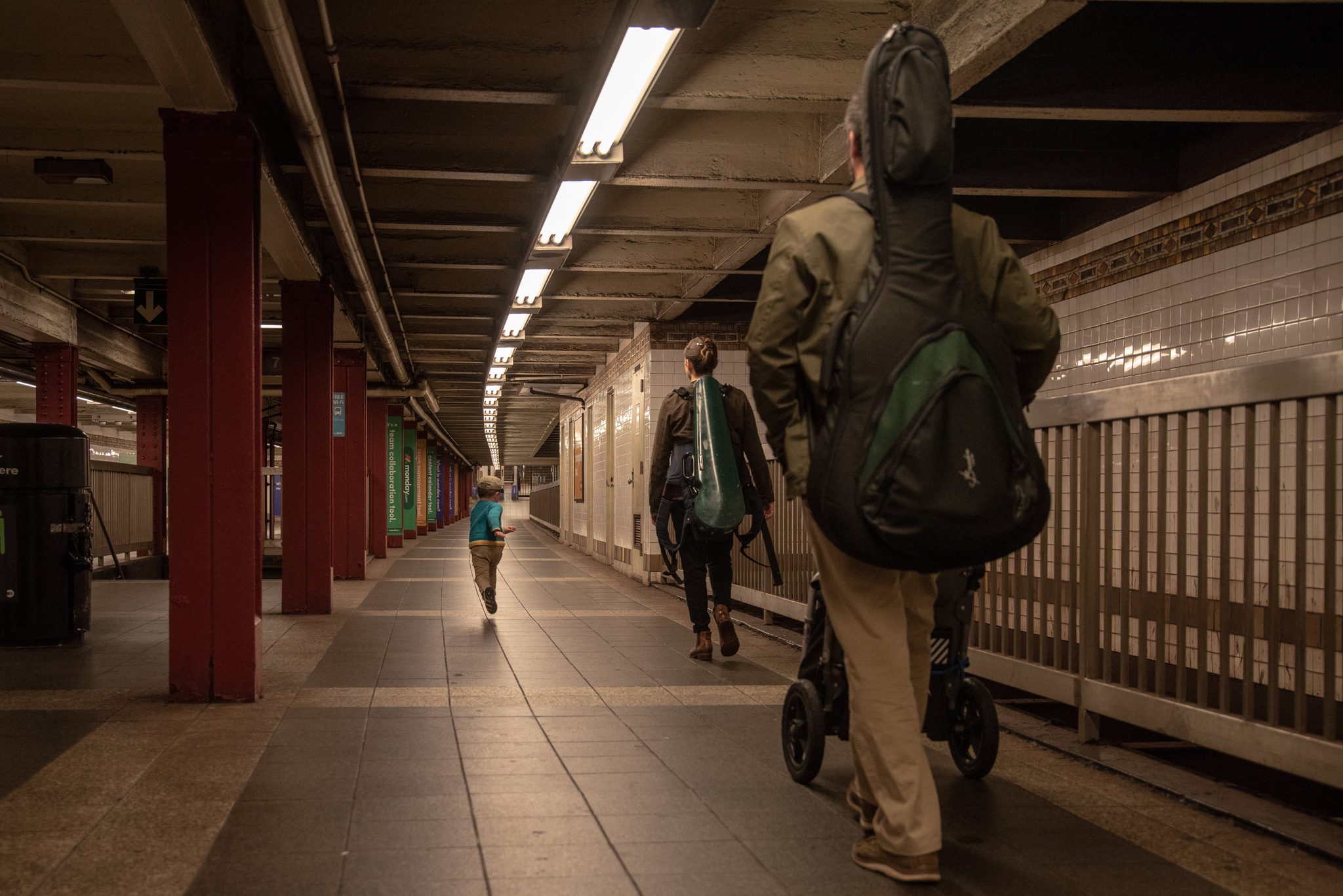 Guitar on his back, Emmet pushes the cart down the platform as Ronin runs on ahead.