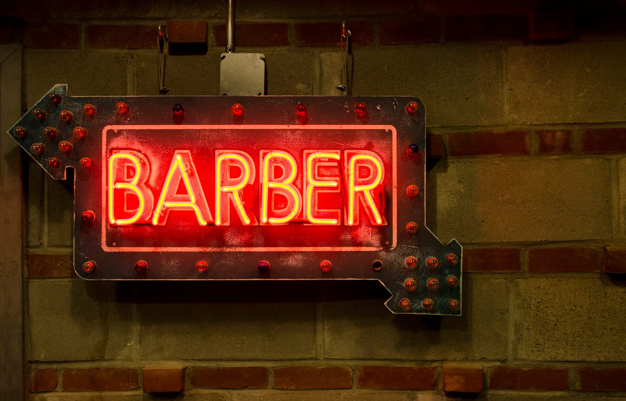 A neon arrow points the way to the barber.