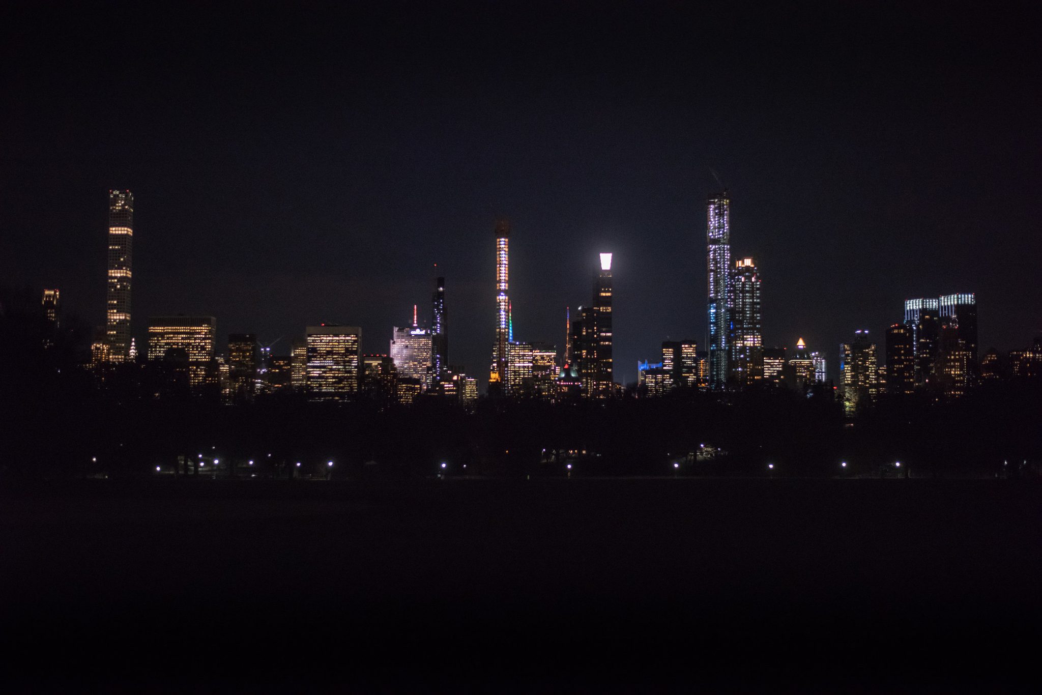 Across the dark water, the towers glow. The city may never sleep, but there are spaces where it breathes.
