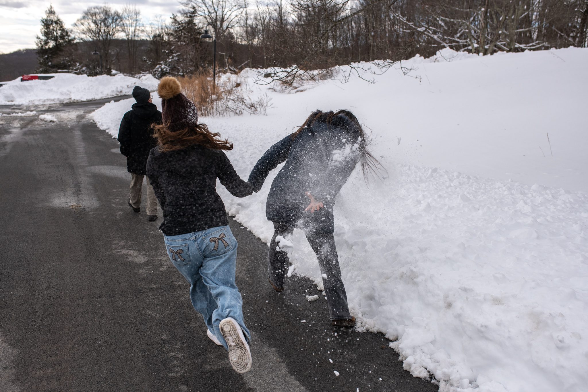 A snowball fight breaks out along the plowed lane.