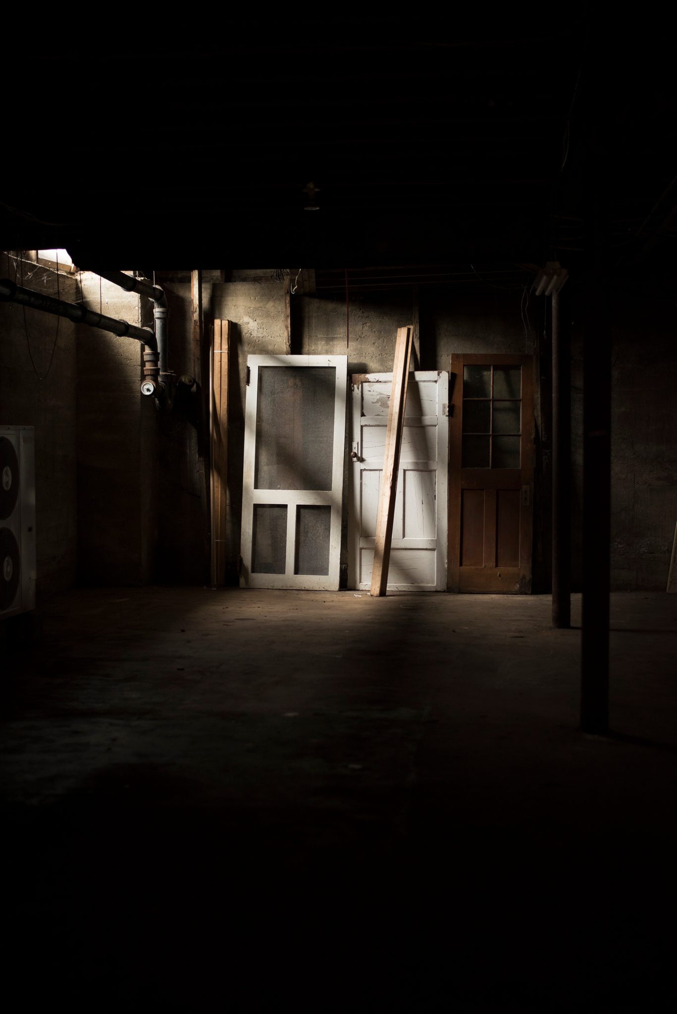 Light falls through a doorway into a dark, empty room.