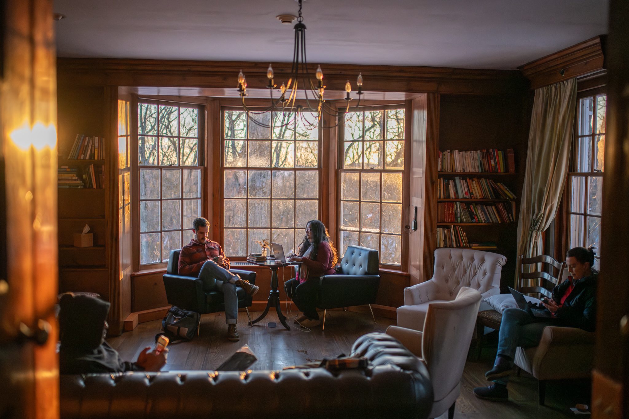 Late sun fills the bay windows of the book-lined sitting room.