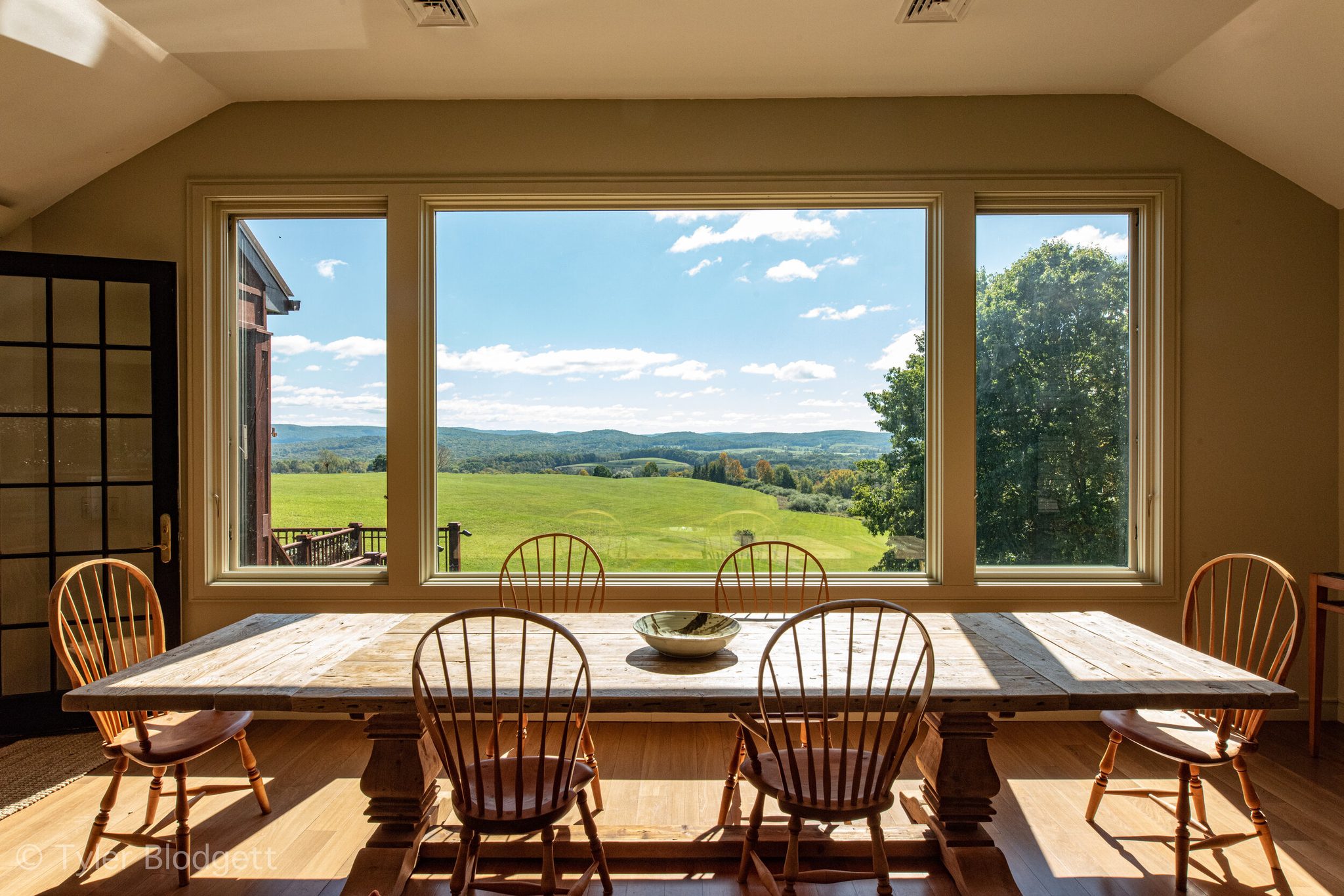 The farm table seats eight, and every seat faces the view.
