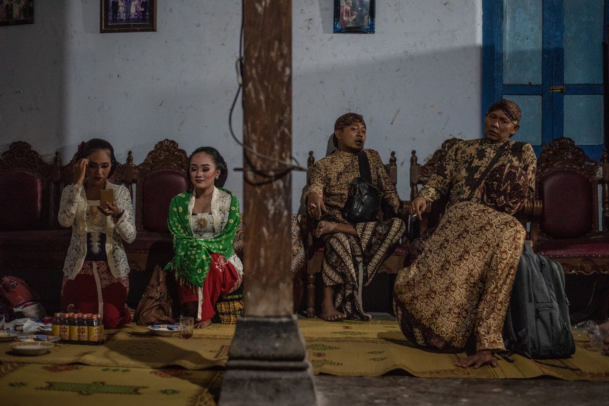 Singers and musicians wait out the hour on carved wooden chairs.