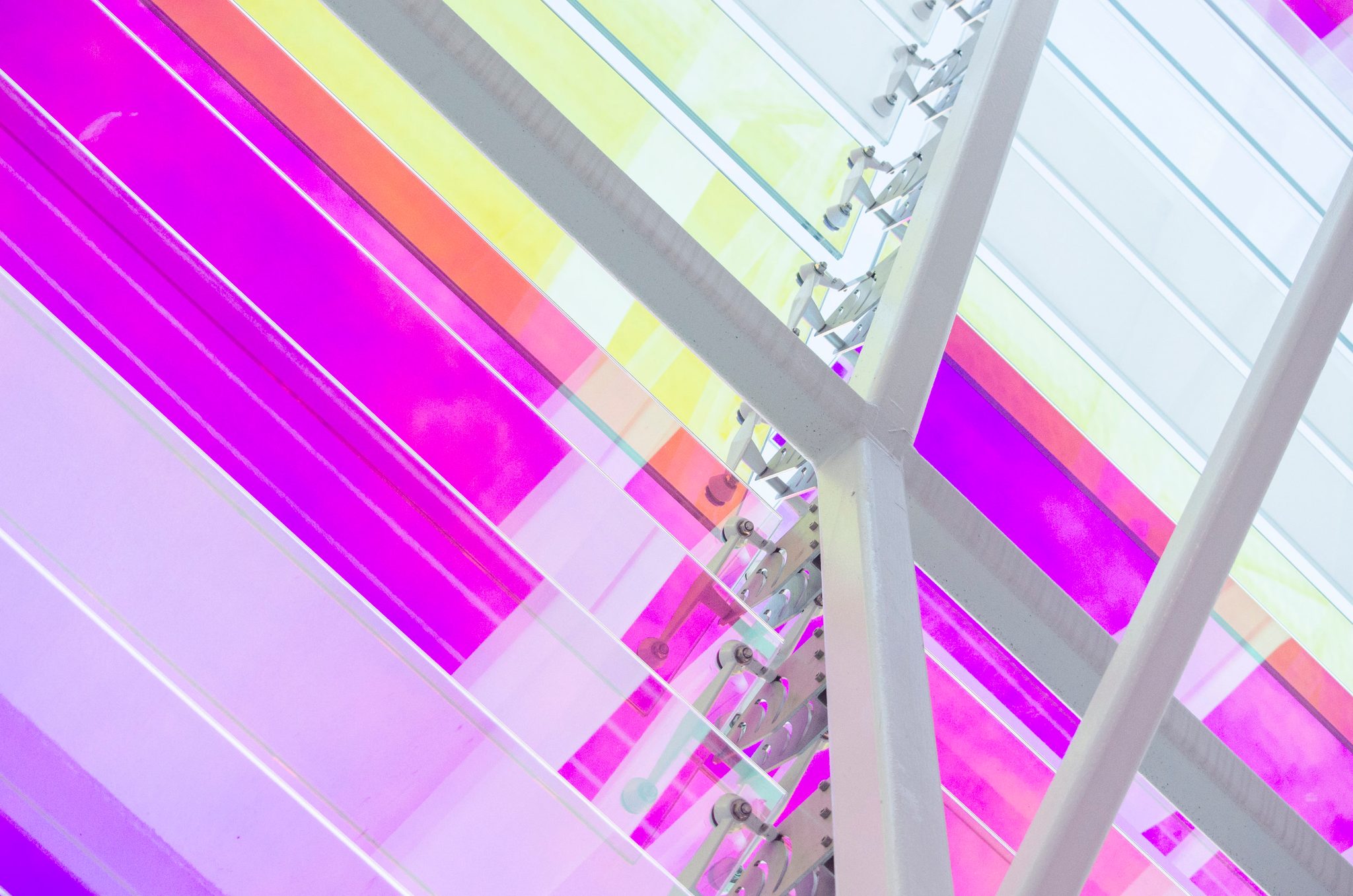 Glass panels in magenta and yellow crisscross overhead.