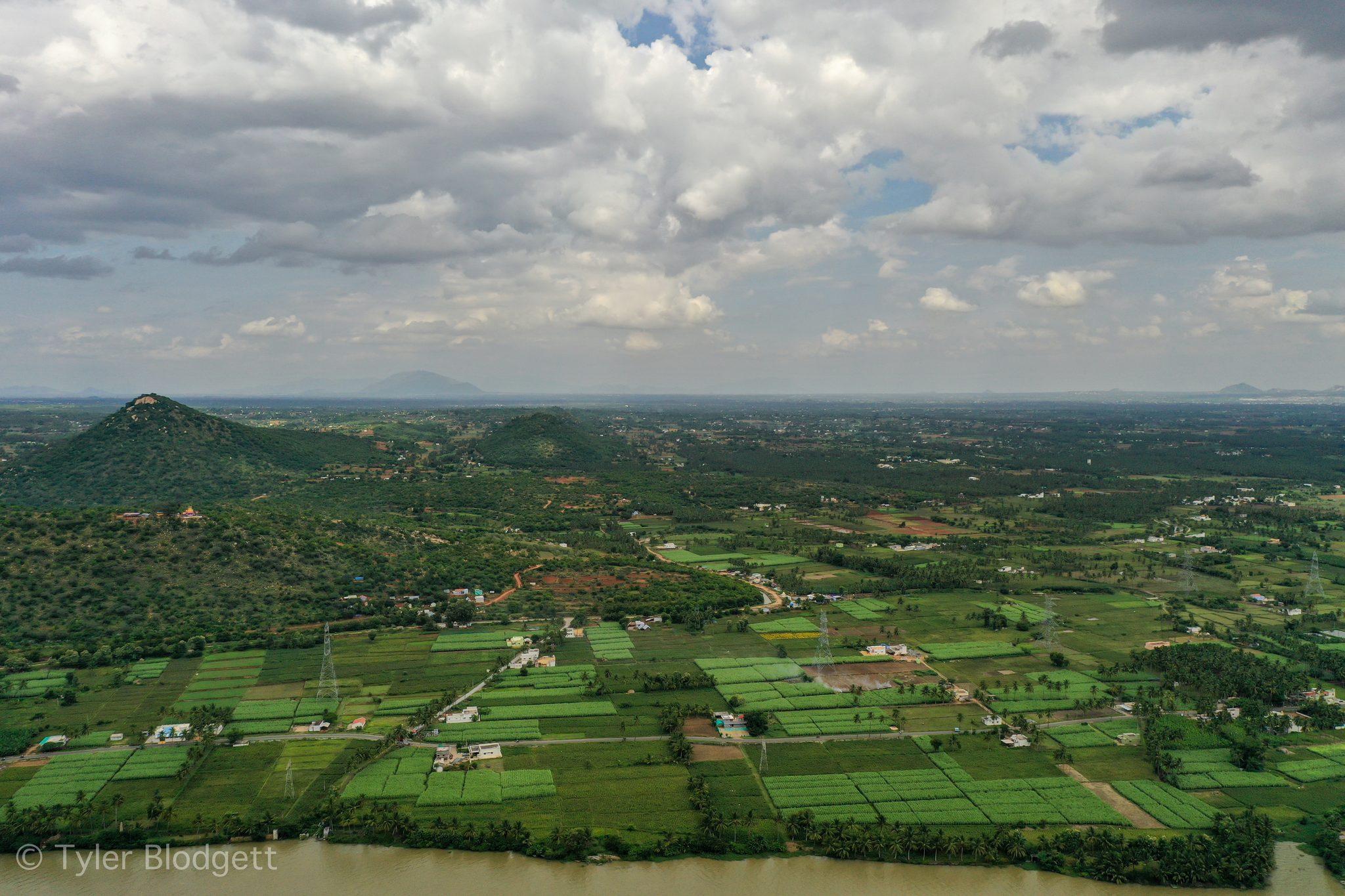 Fields and palms spread across the valley toward a distant range.