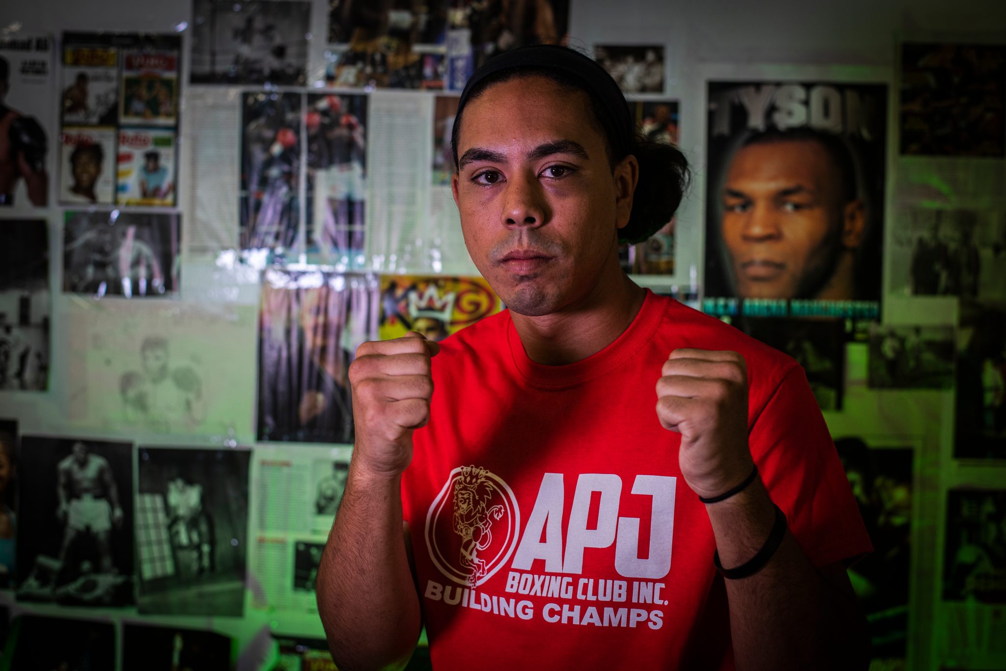 Hair tied back, fists up, a fighter against the wall of champions.