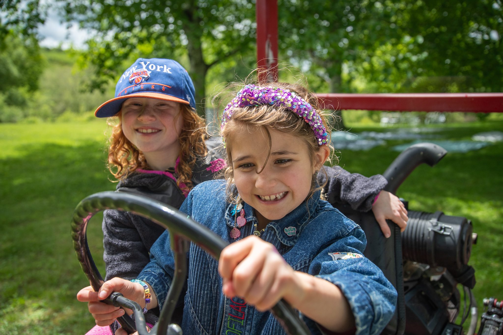 Two girls take a turn at the wheel of the old red tractor.