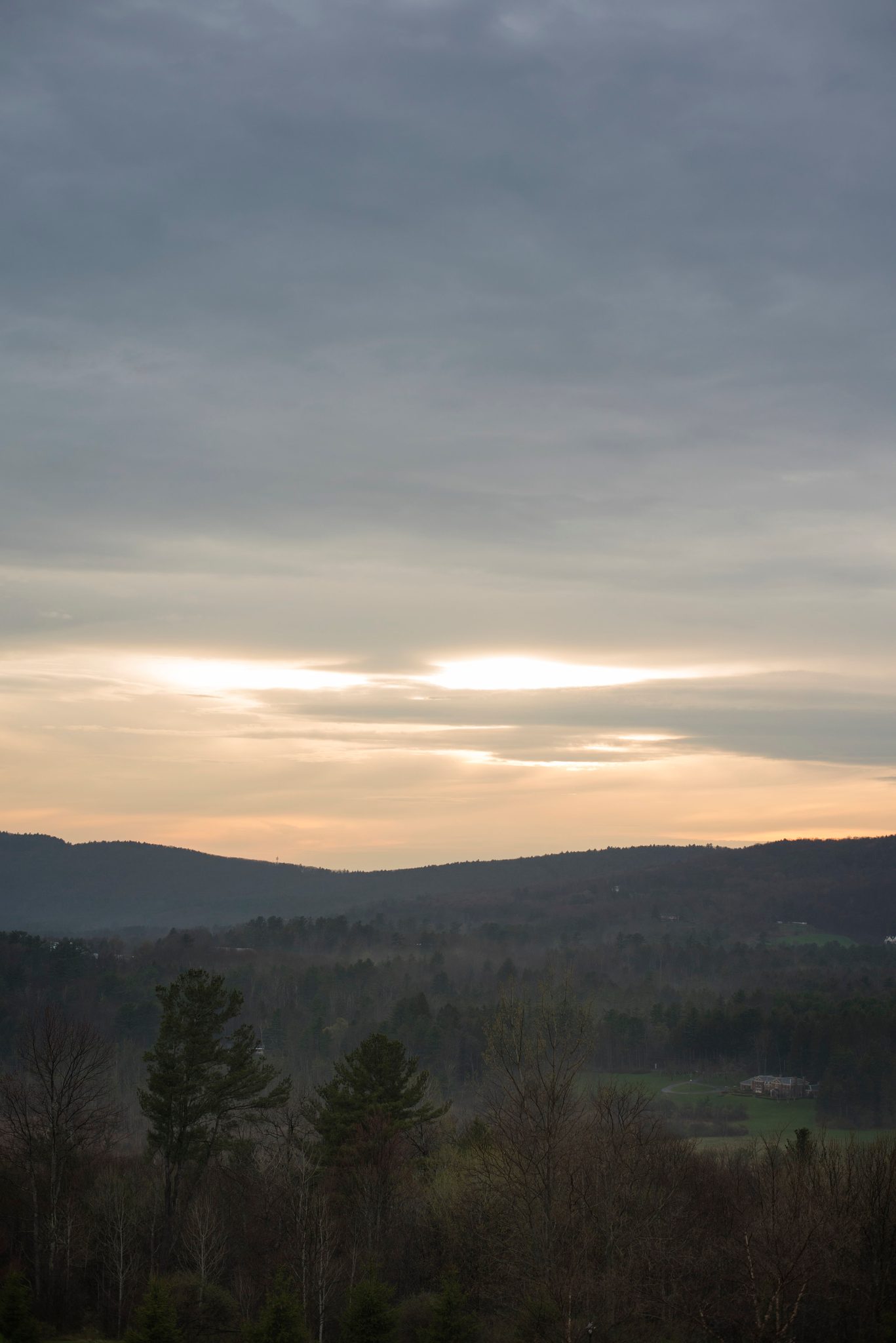 The last light breaks through the clouds over the hills. To the seeker, the divinity of light will change only from its source, never from its majesty.