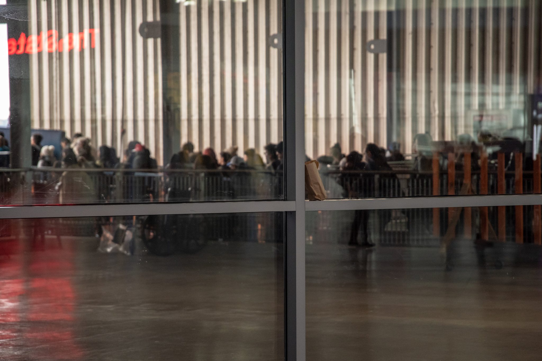 Through the glass, the crowd presses toward the gates for the next boat.