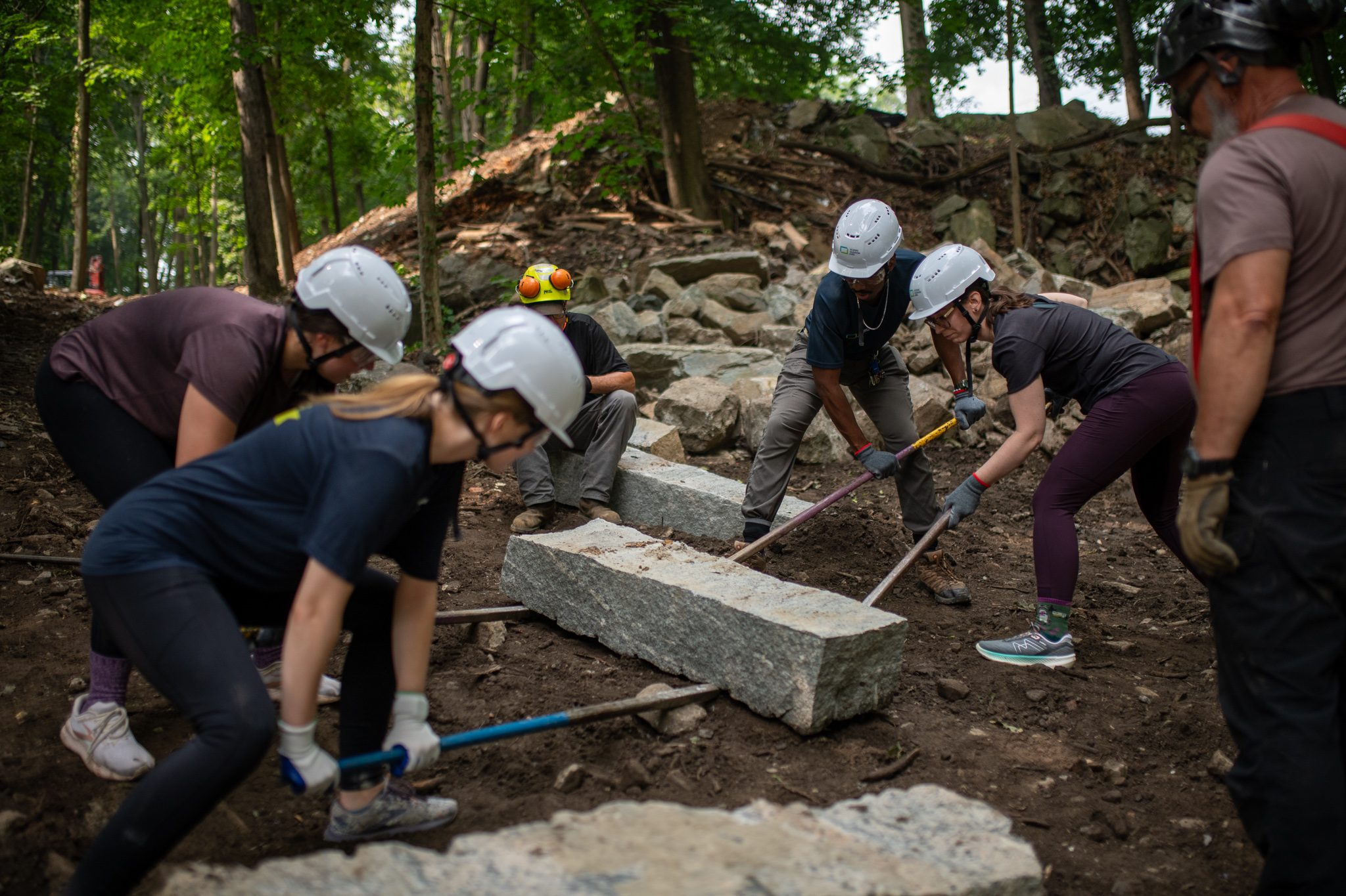 Five bars and ten hands move a granite step into line.