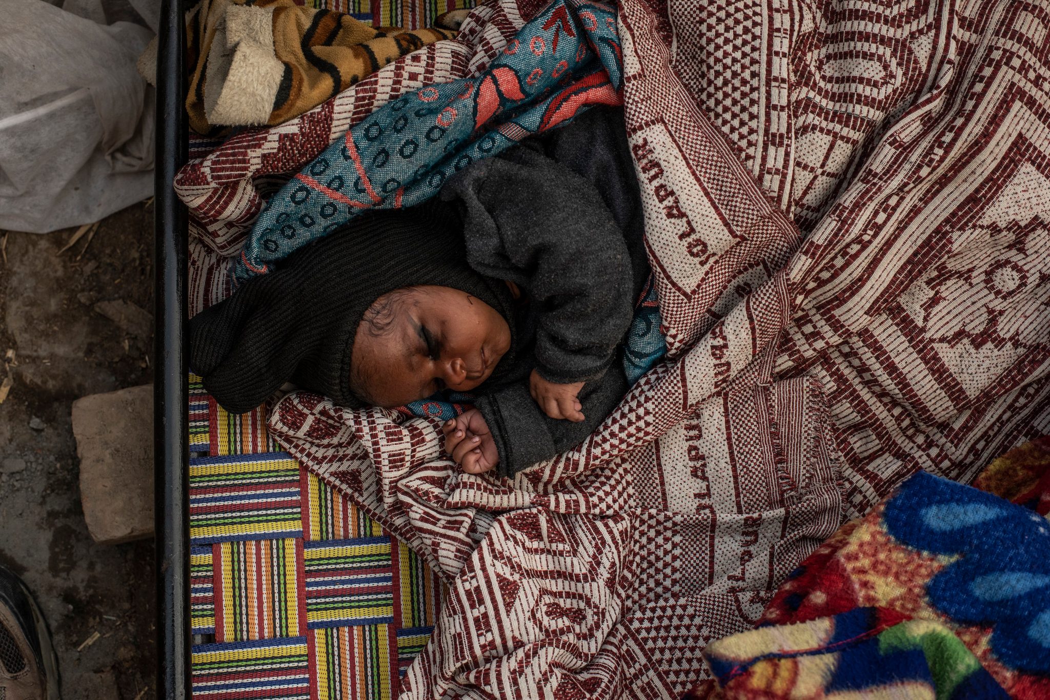 One month old granddaughter of Vimla sleeps on cot.