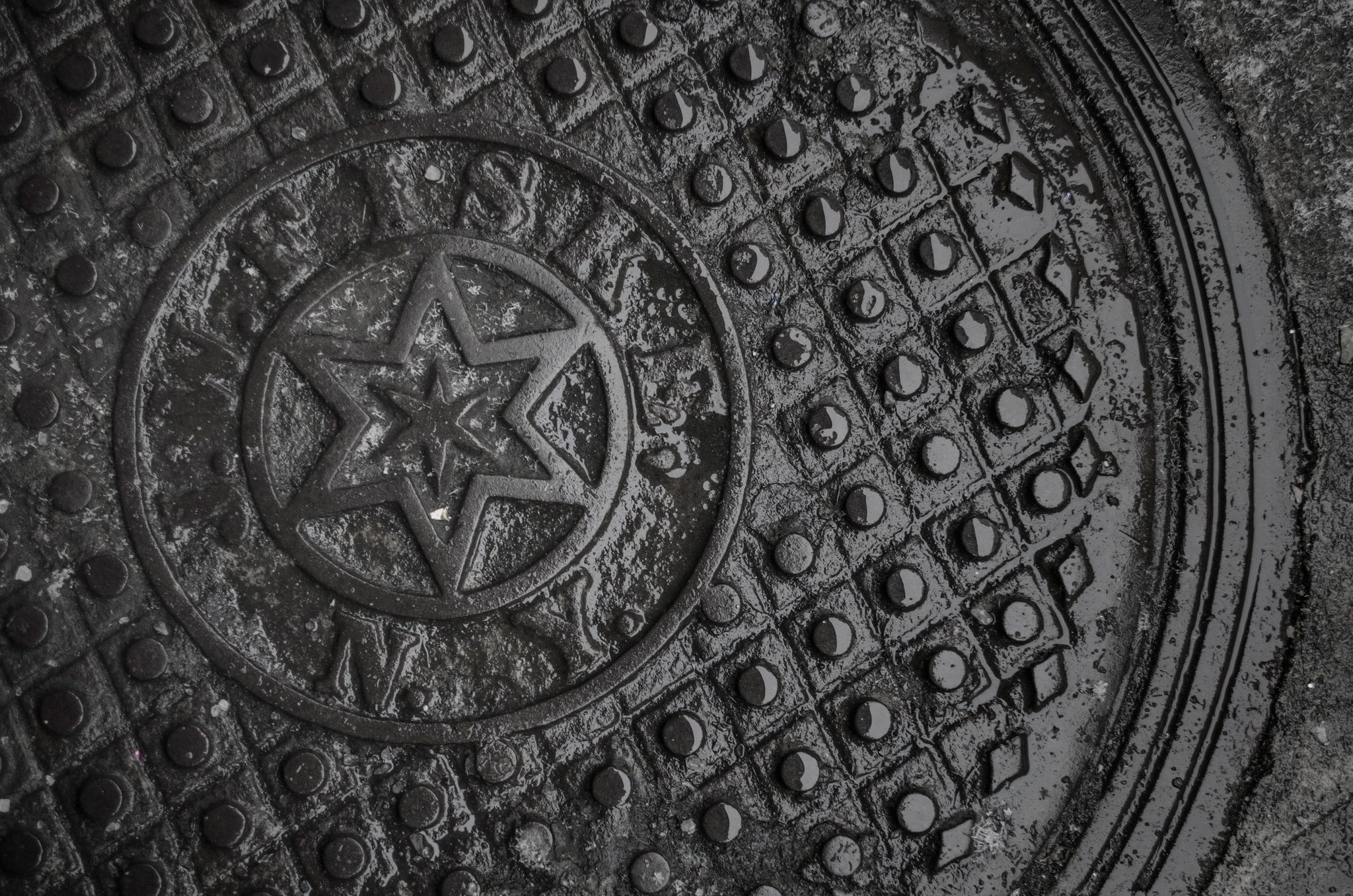A star cast in the iron of a manhole cover.