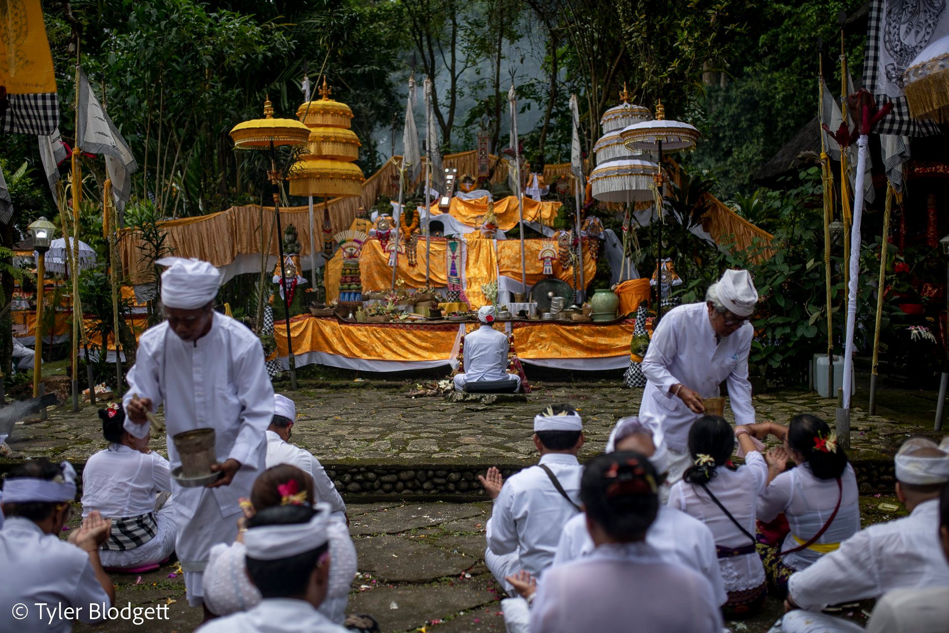Temple elders move through the rows sprinkling holy water over bowed heads.