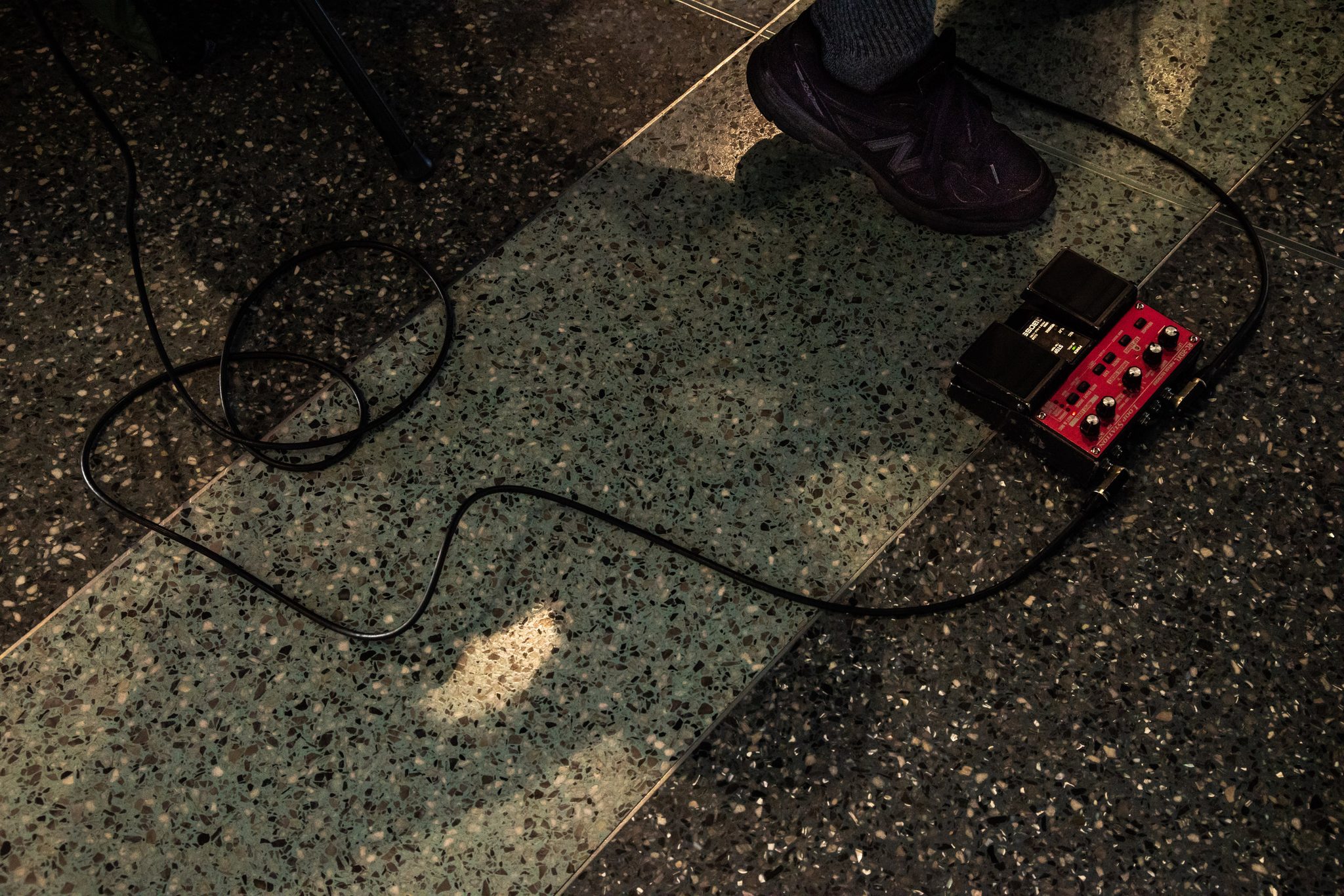 A red pedal and a coil of cable on the terrazzo floor.