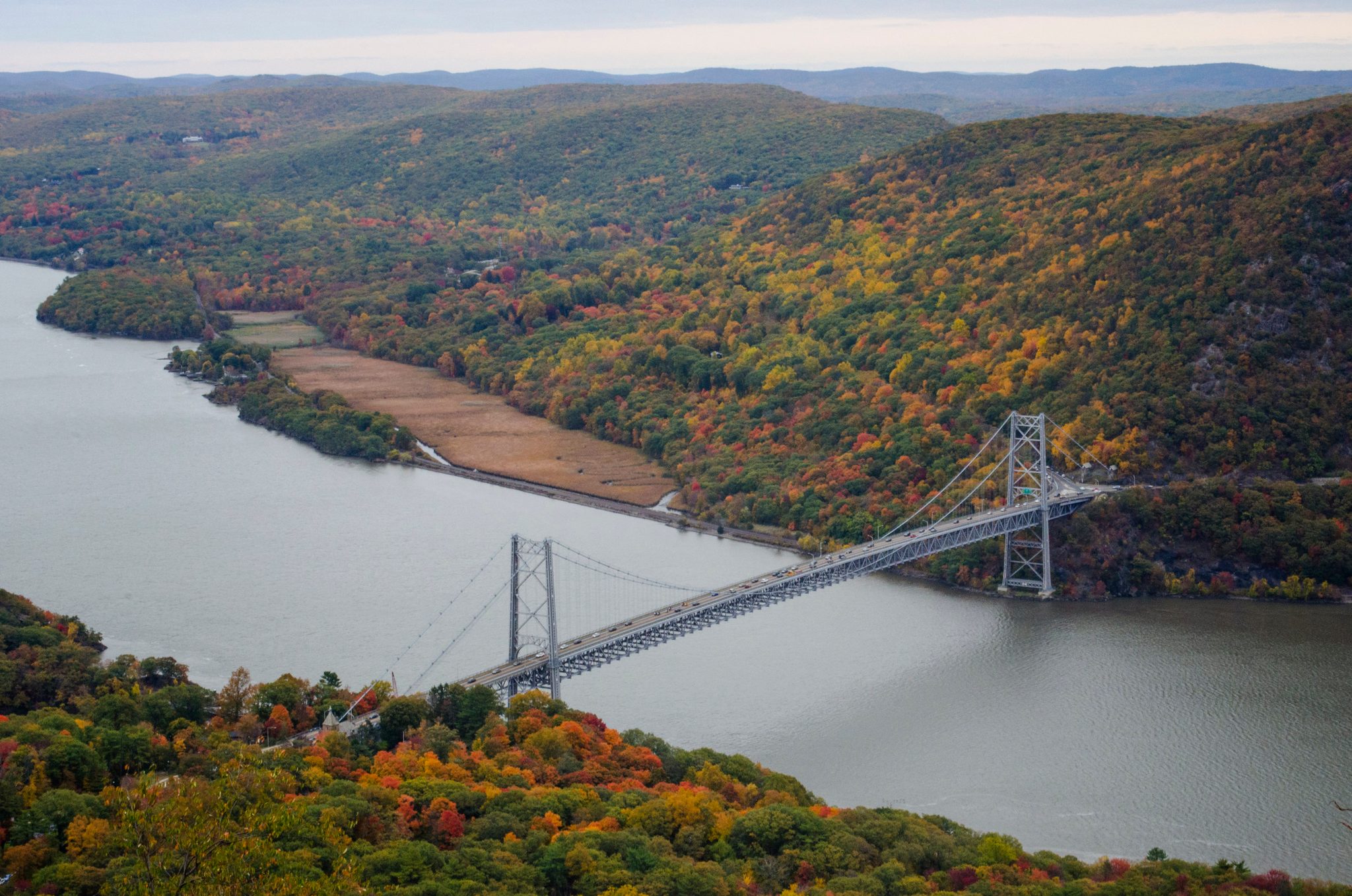 The Bear Mountain Bridge spans the Hudson below a mountainside in full color.