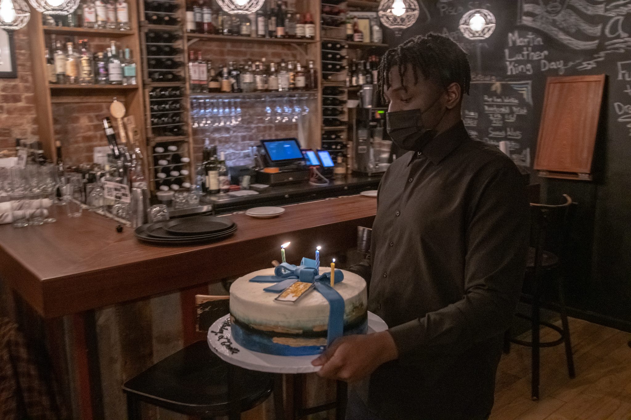 The cake arrives, candles lit.