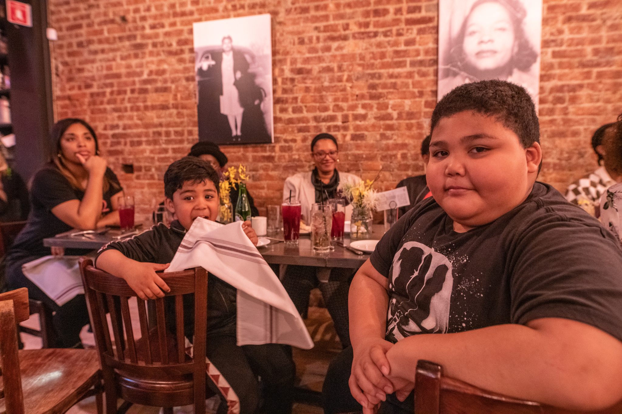 Two young diners at a table, one looking straight into the lens.