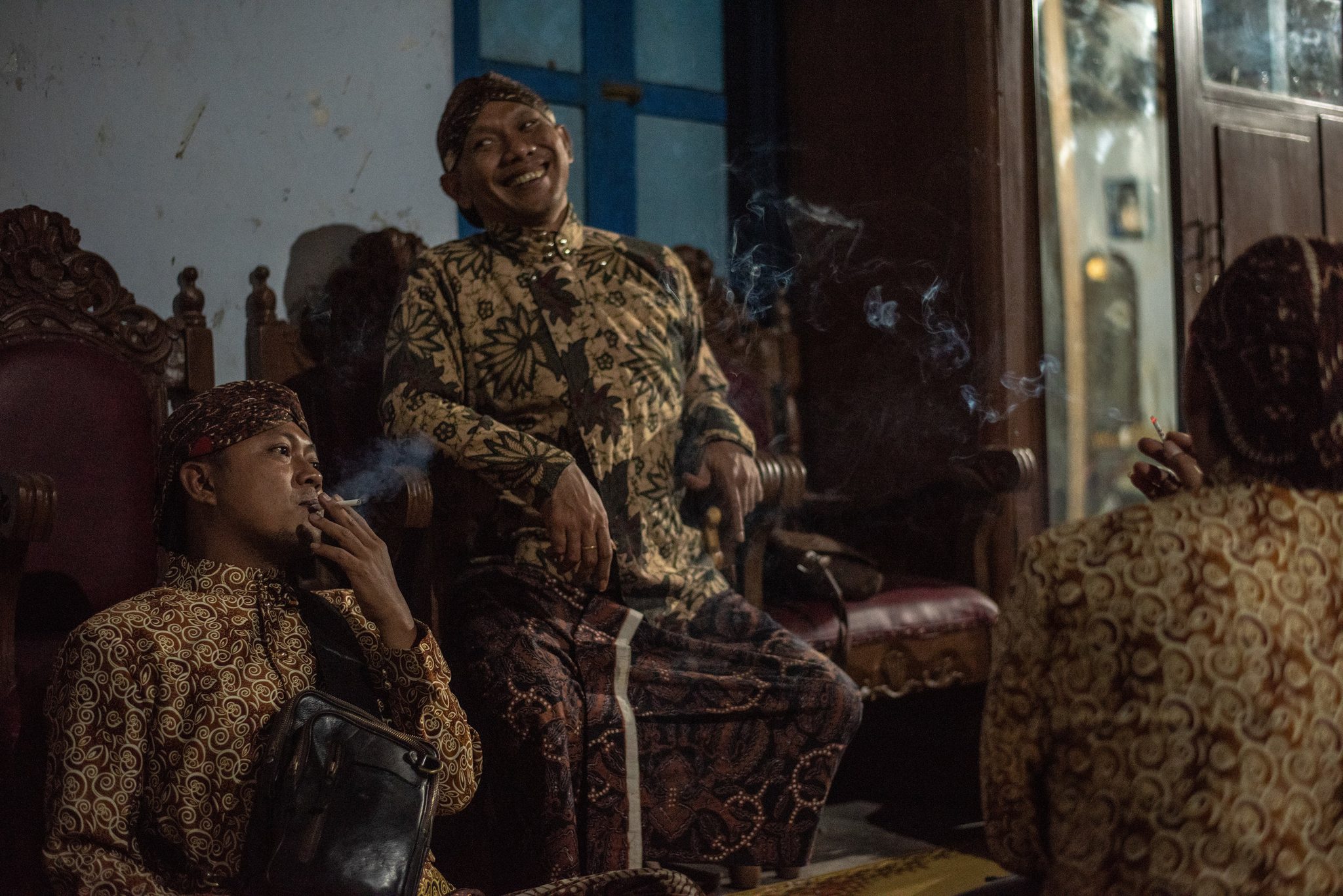 Smoke drifts through the room as the performers laugh and wait.