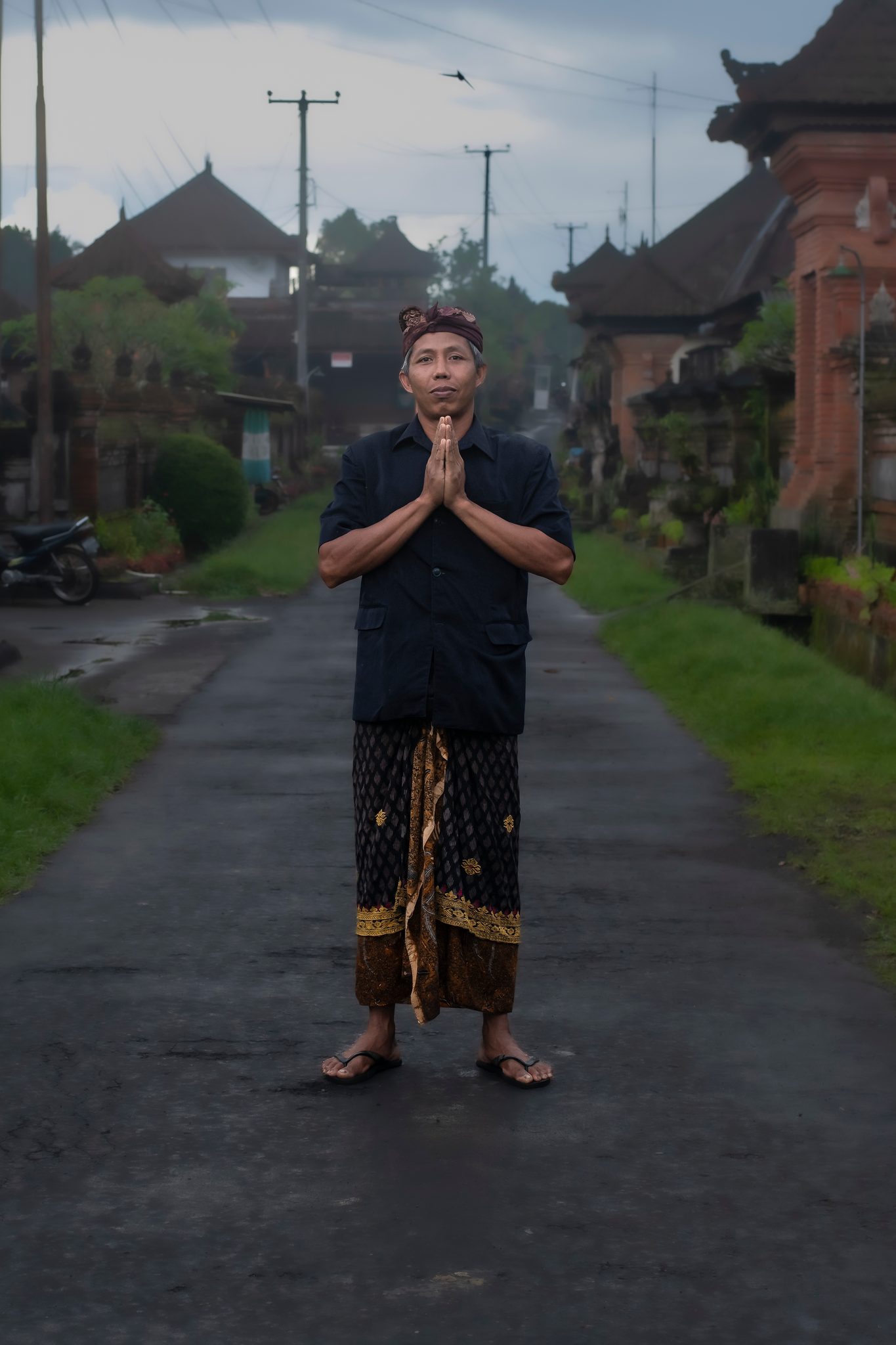 A young man stands in the lane with his hands pressed together.