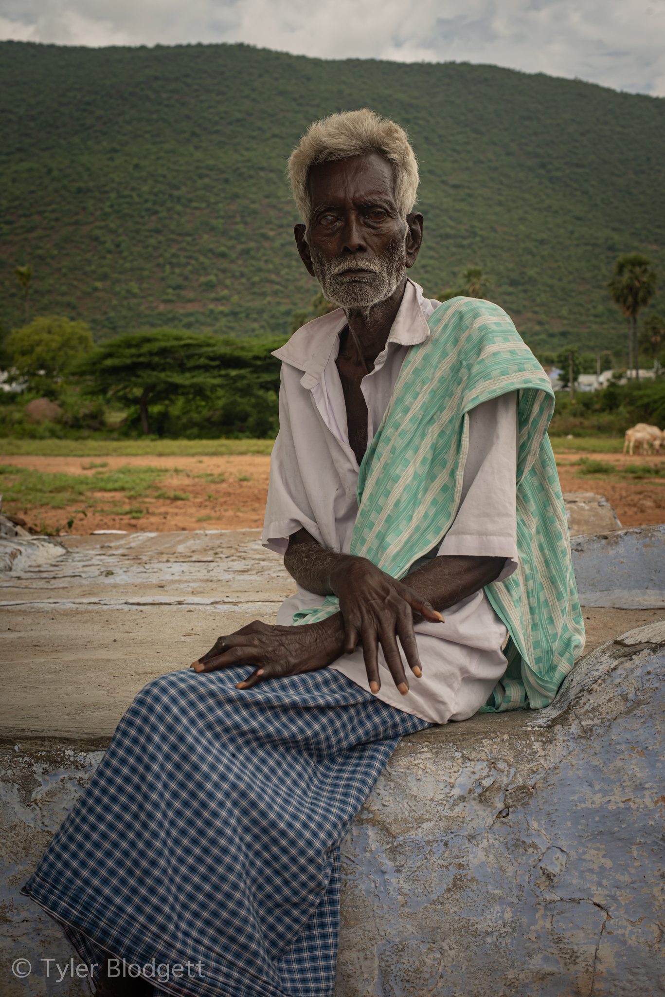 Towel on his shoulder, the elder looks straight into the lens.