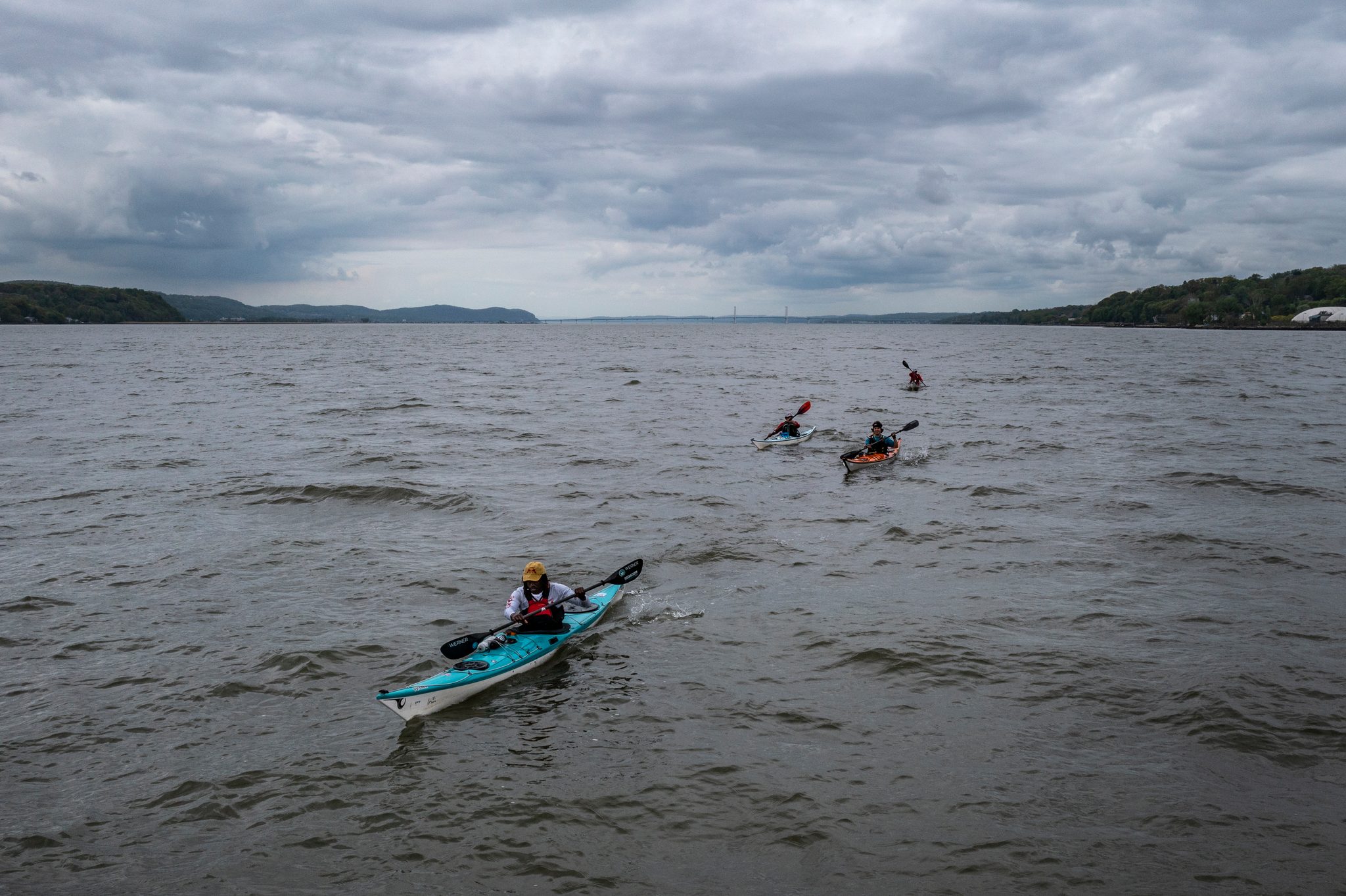 Grey sky, grey chop. A small flotilla of kayaks spreads out across the Hudson under low cloud.