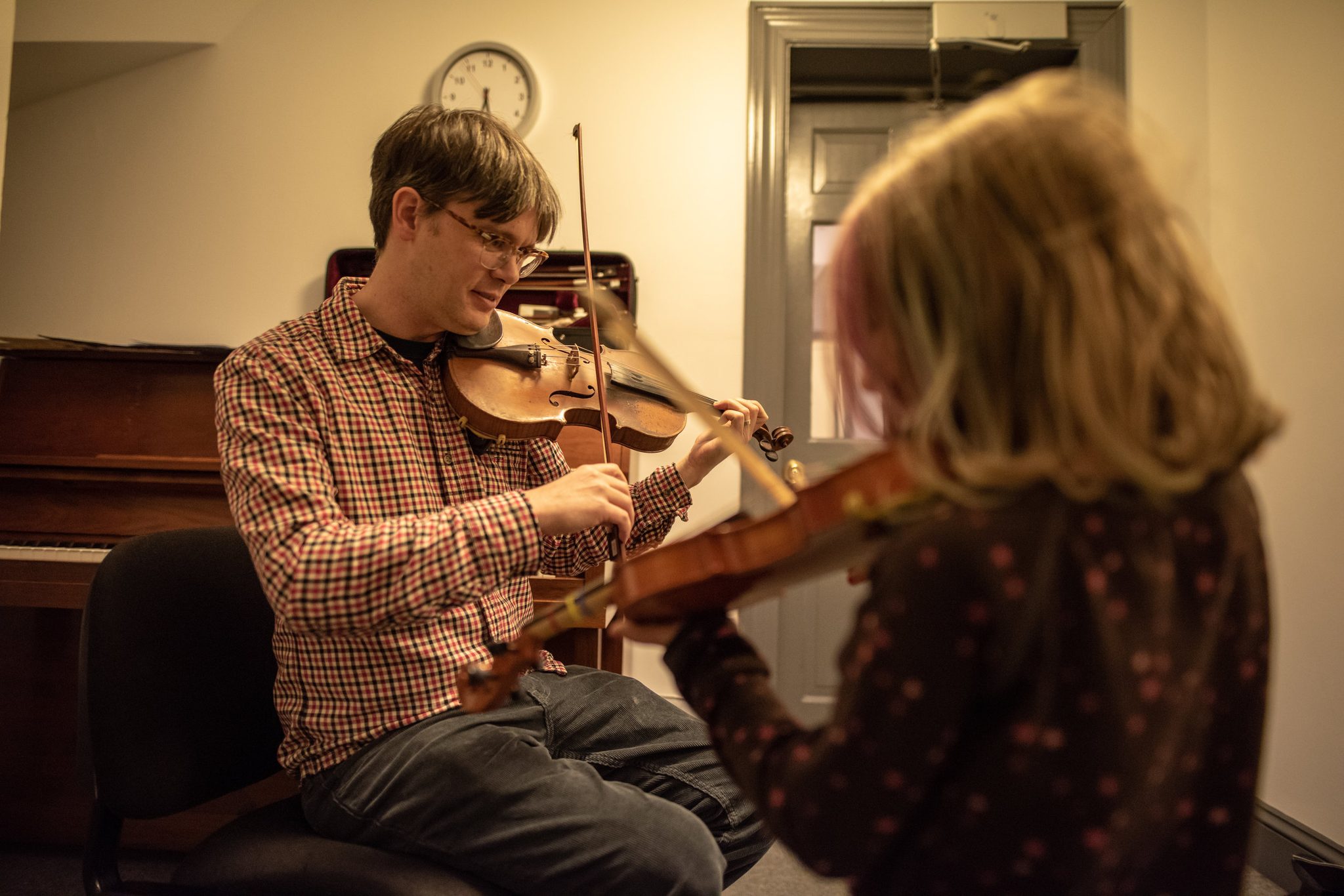 Here Tom provides violin lessons to students