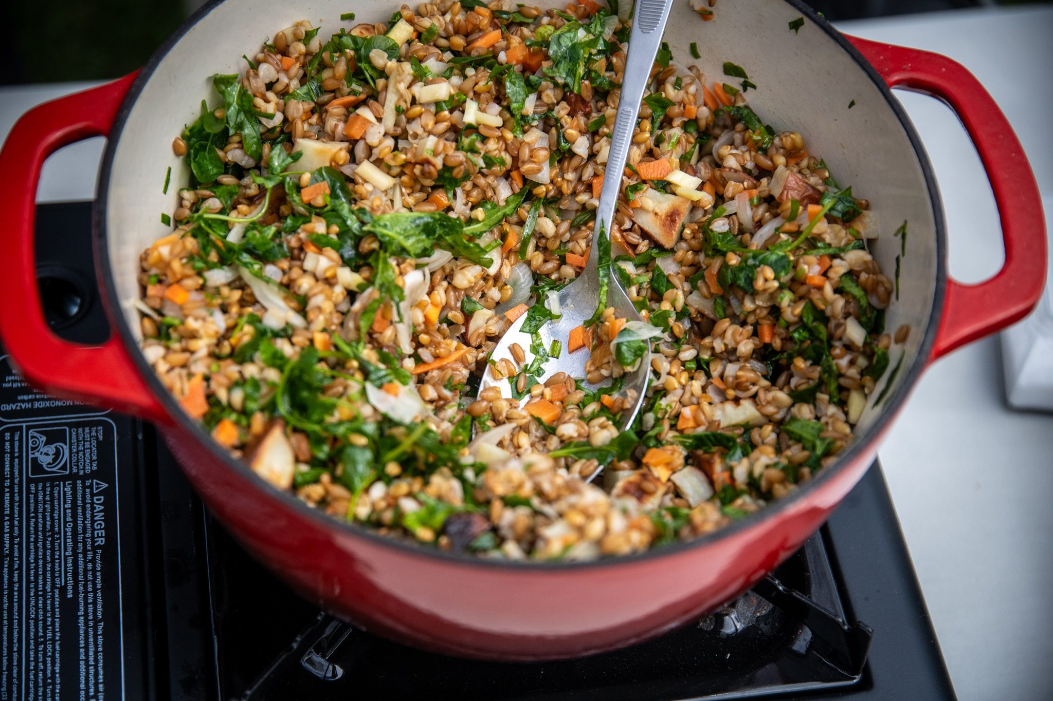 Grains and greens come together in a red pot.
