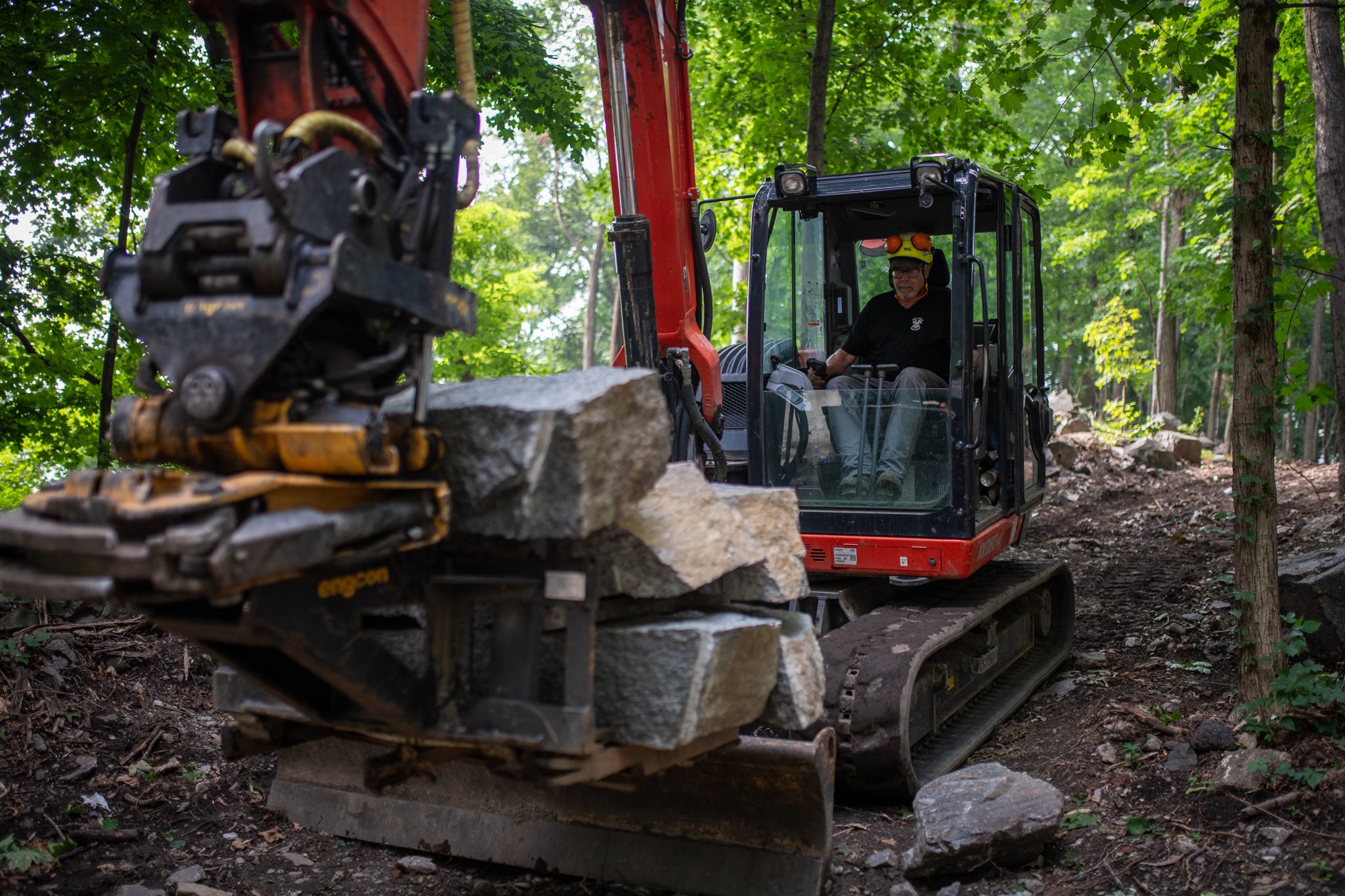 A stack of granite rides in the grapple toward the next step.