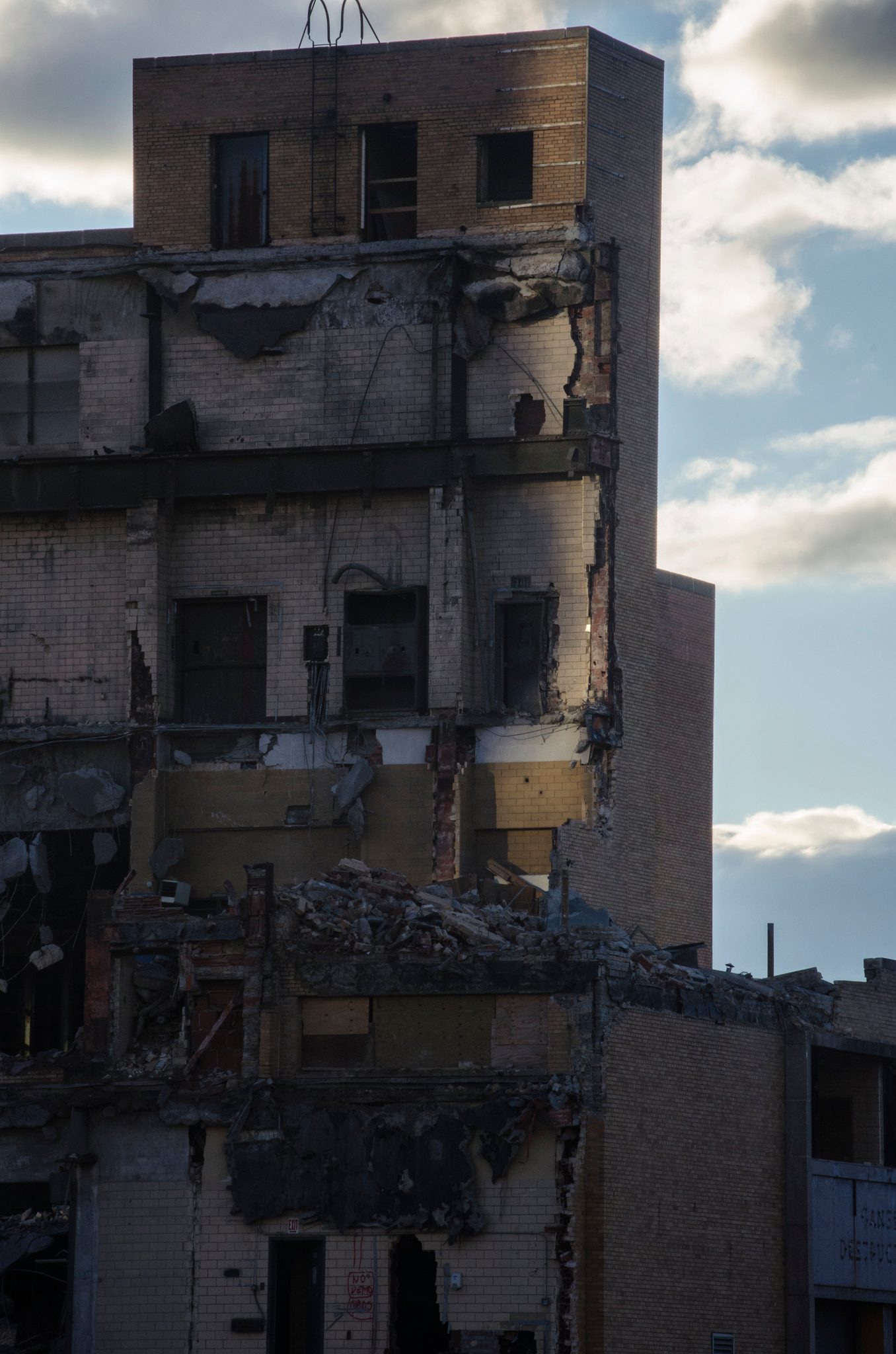 A gutted building stands open to the sky, floors exposed like a dollhouse.