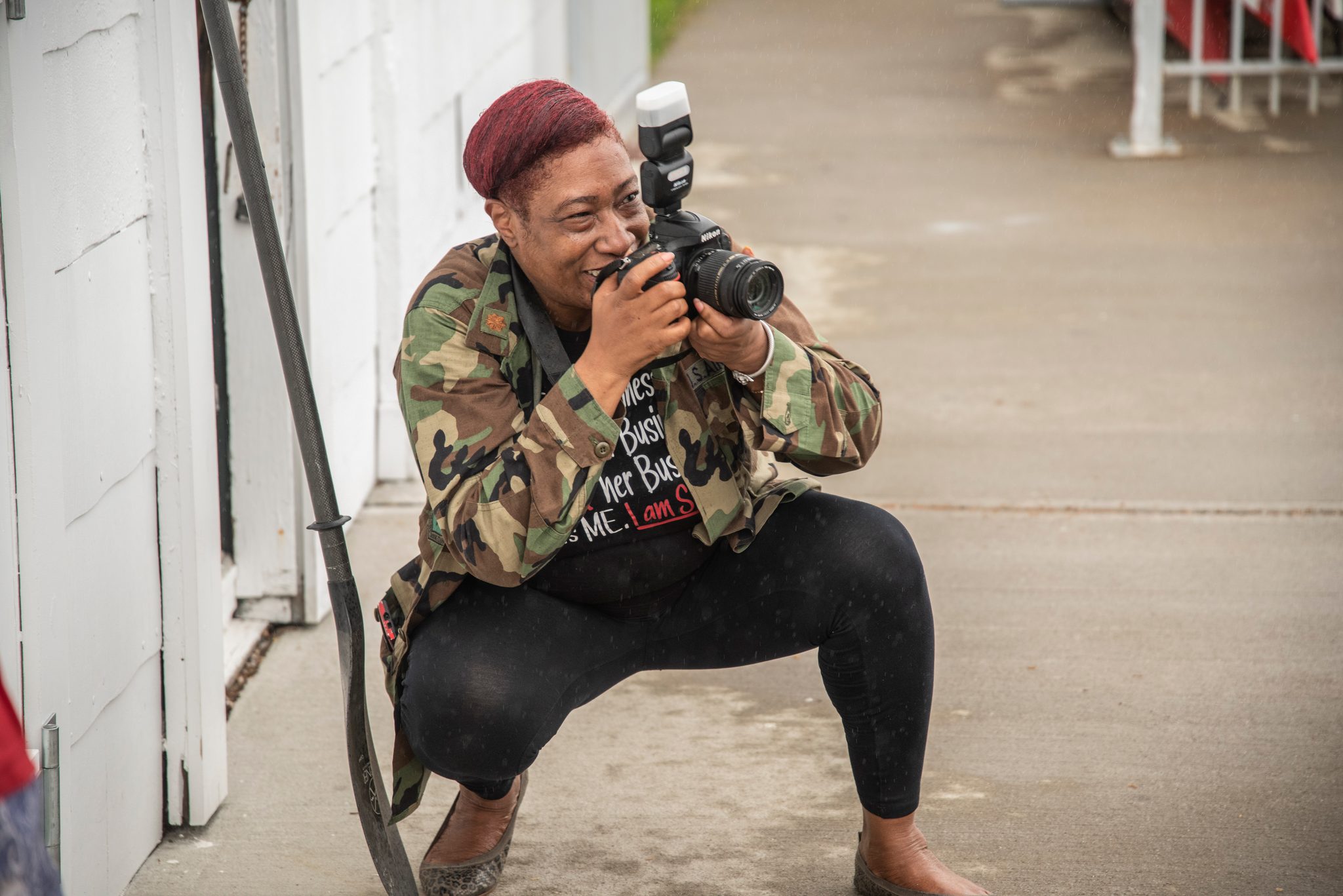 A photographer in a camo jacket drops low on the boardwalk to get the shot.