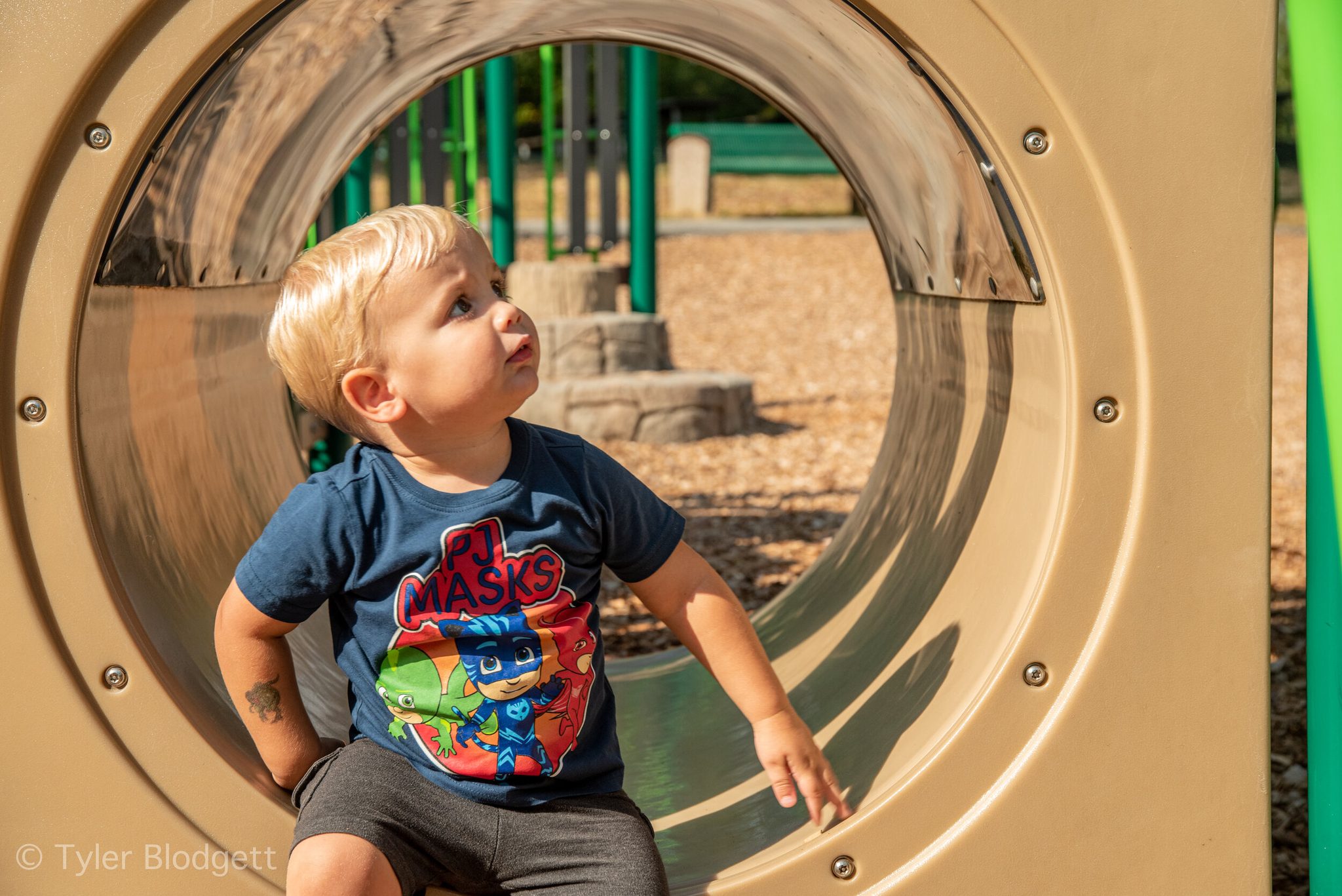 A toddler peers out from the end of the tunnel, deciding which way to go next.