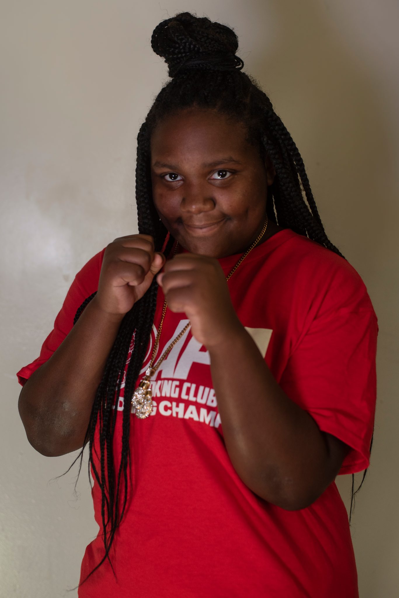 Guard up, braids falling over her fists.