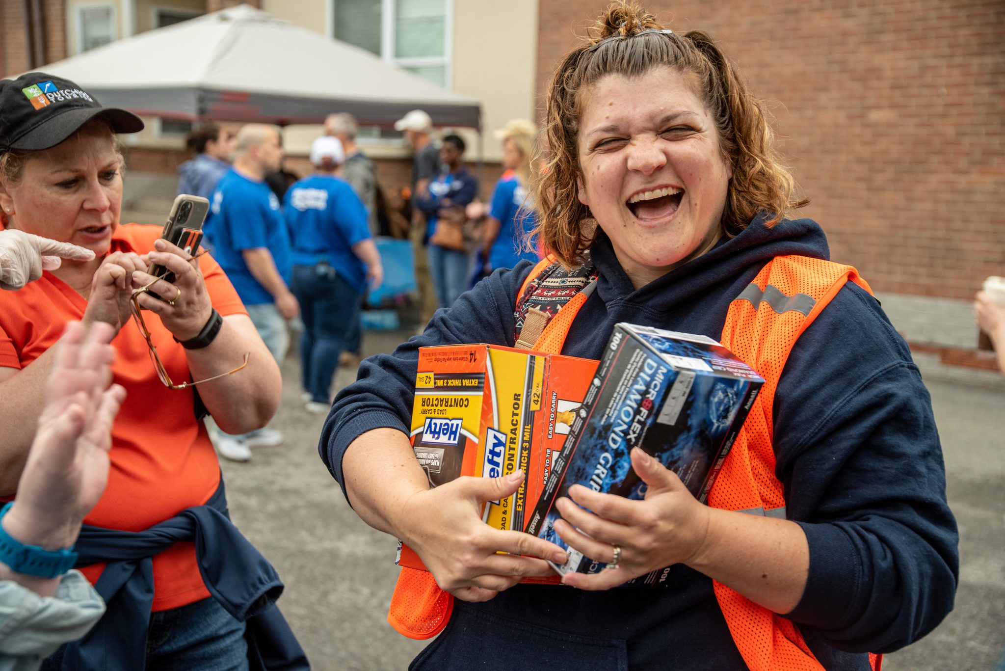 Supplies in her arms and a laugh she can't hold in.