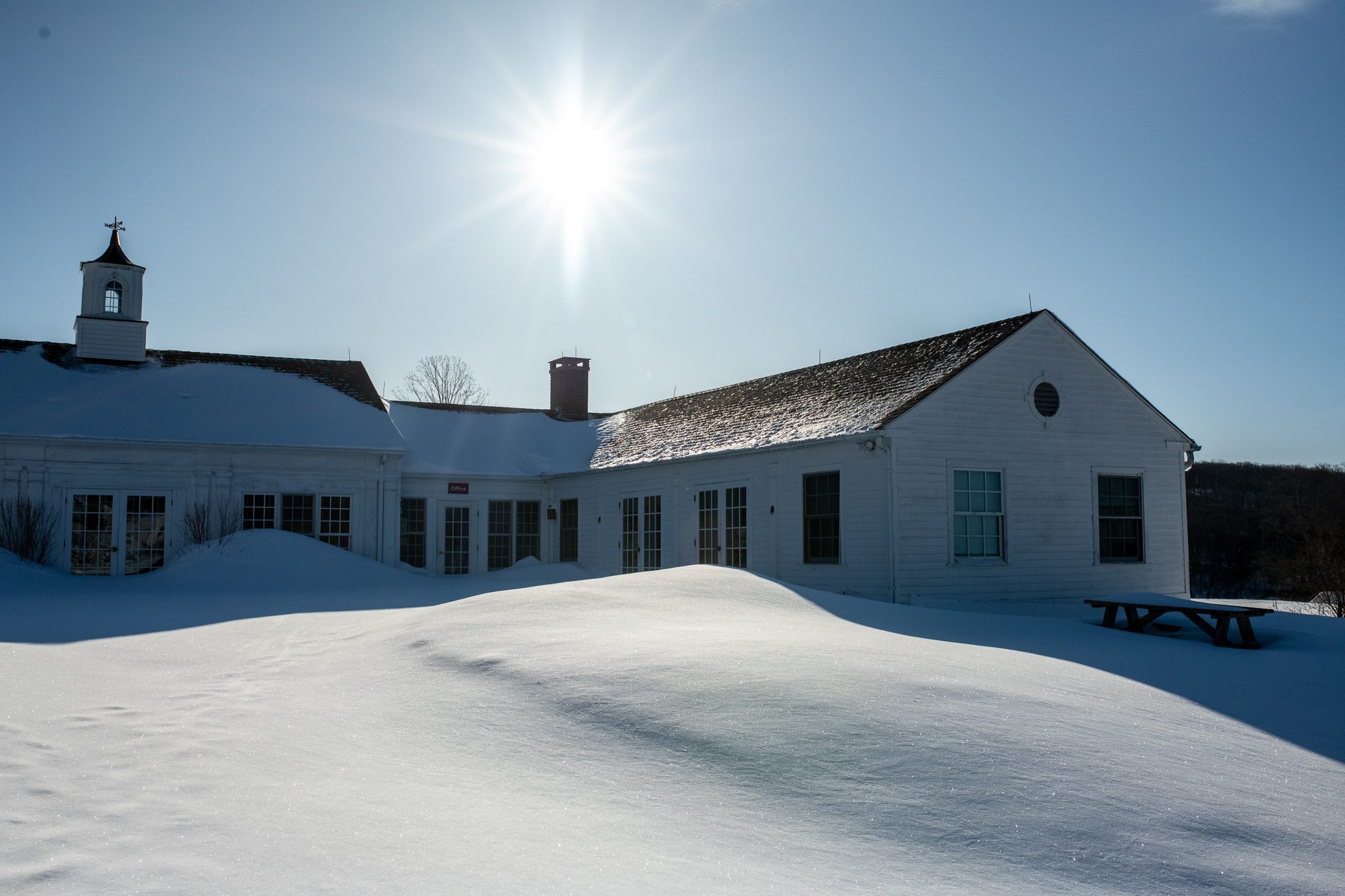 Winter sun over the white clapboard hall and its cupola.